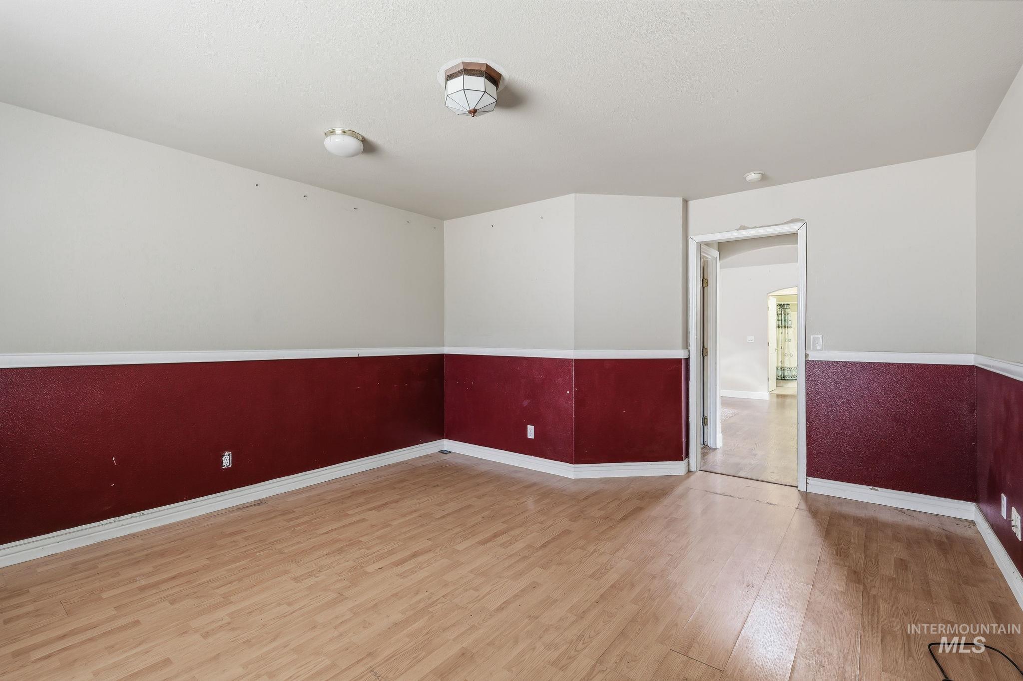 Neutral walls with a dark accent wainscoting and light wood-finish flooring