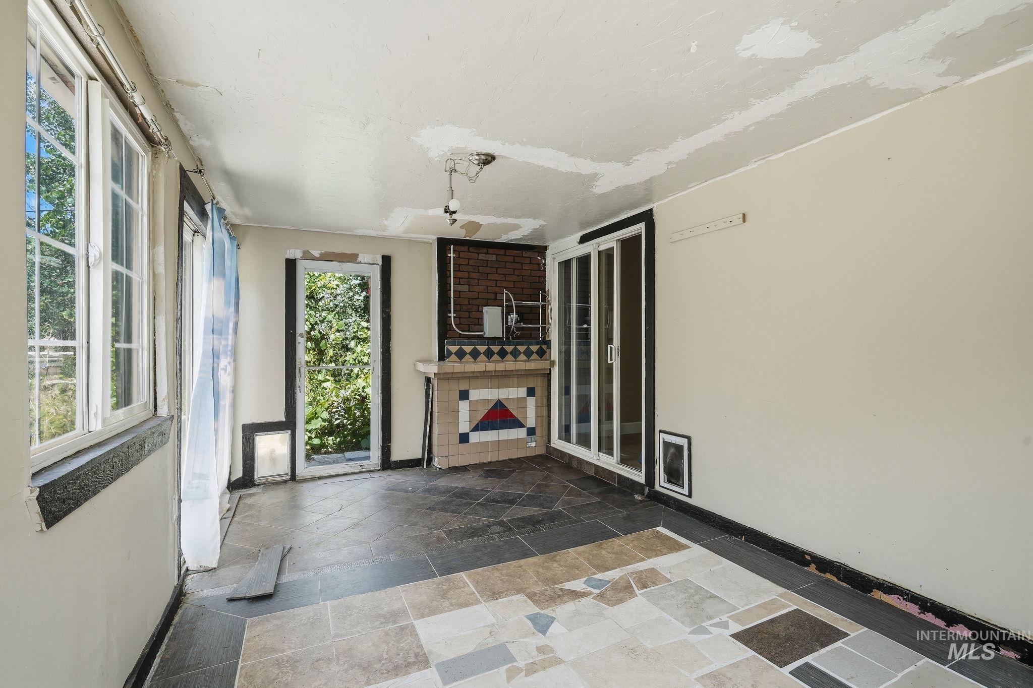 Room featuring multi-tone tile flooring and exposed brick accents