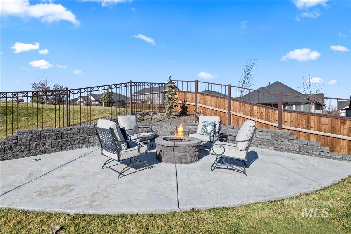 Fenced backyard with a patio area and a fire pit