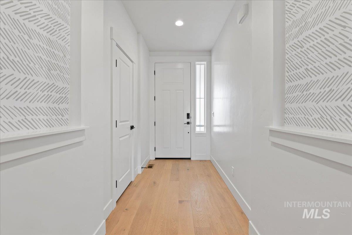 Doorway with wood finished floors and recessed lighting