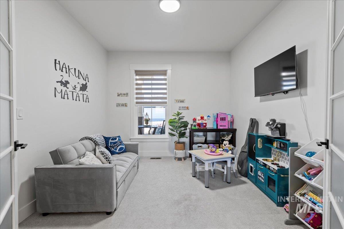 Rec room featuring light colored carpet and baseboards