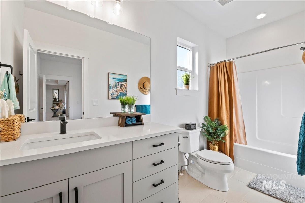 Full bathroom featuring vanity, shower / tub combo, light tile patterned floors, and recessed lighting