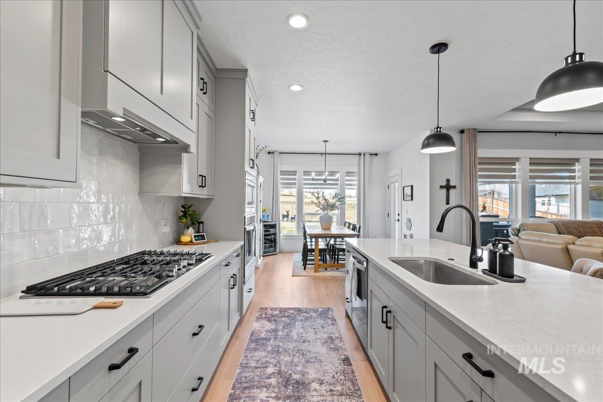 Kitchen featuring pendant lighting, gray cabinets, and light wood-type flooring