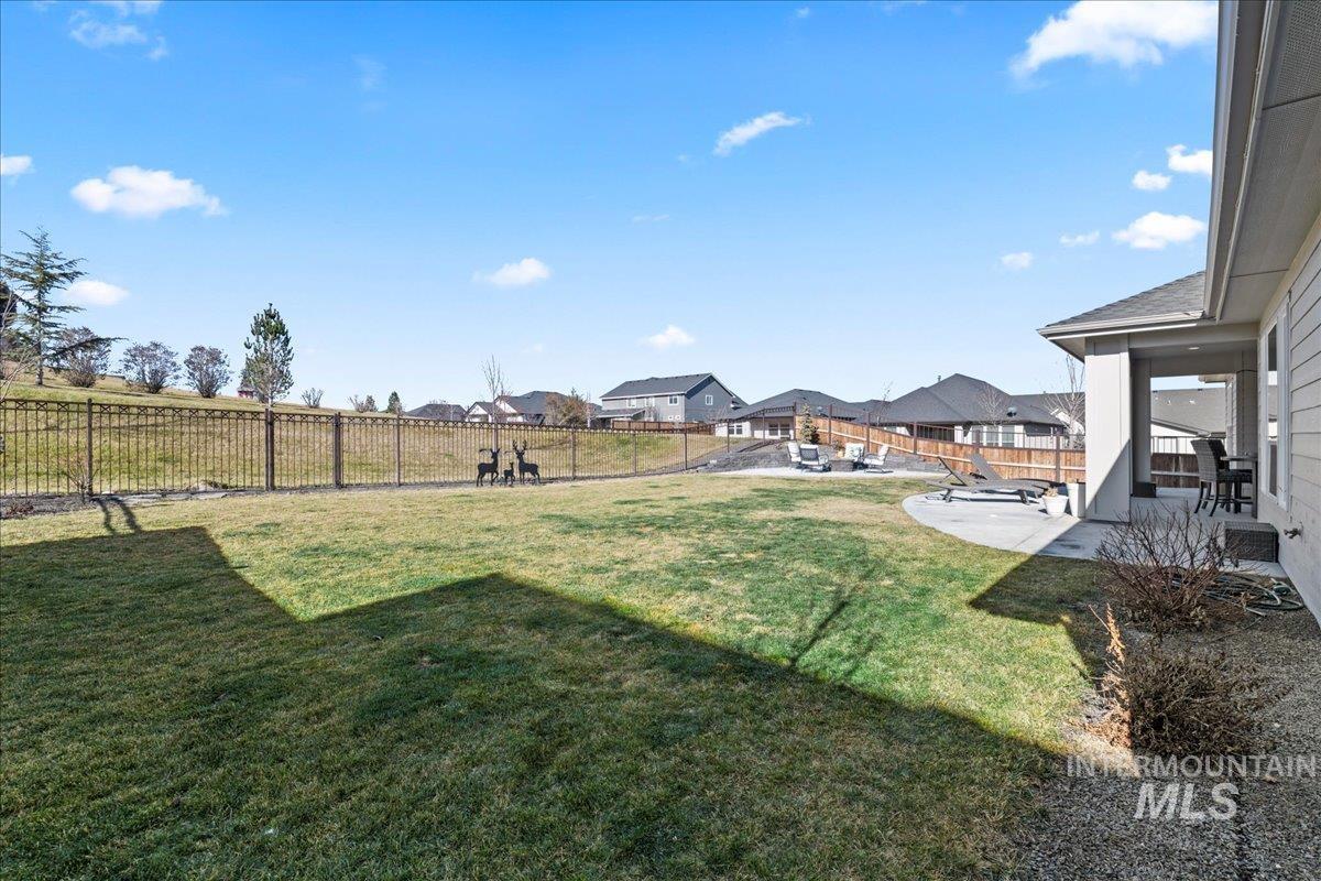 Fenced backyard featuring a residential view and a patio area