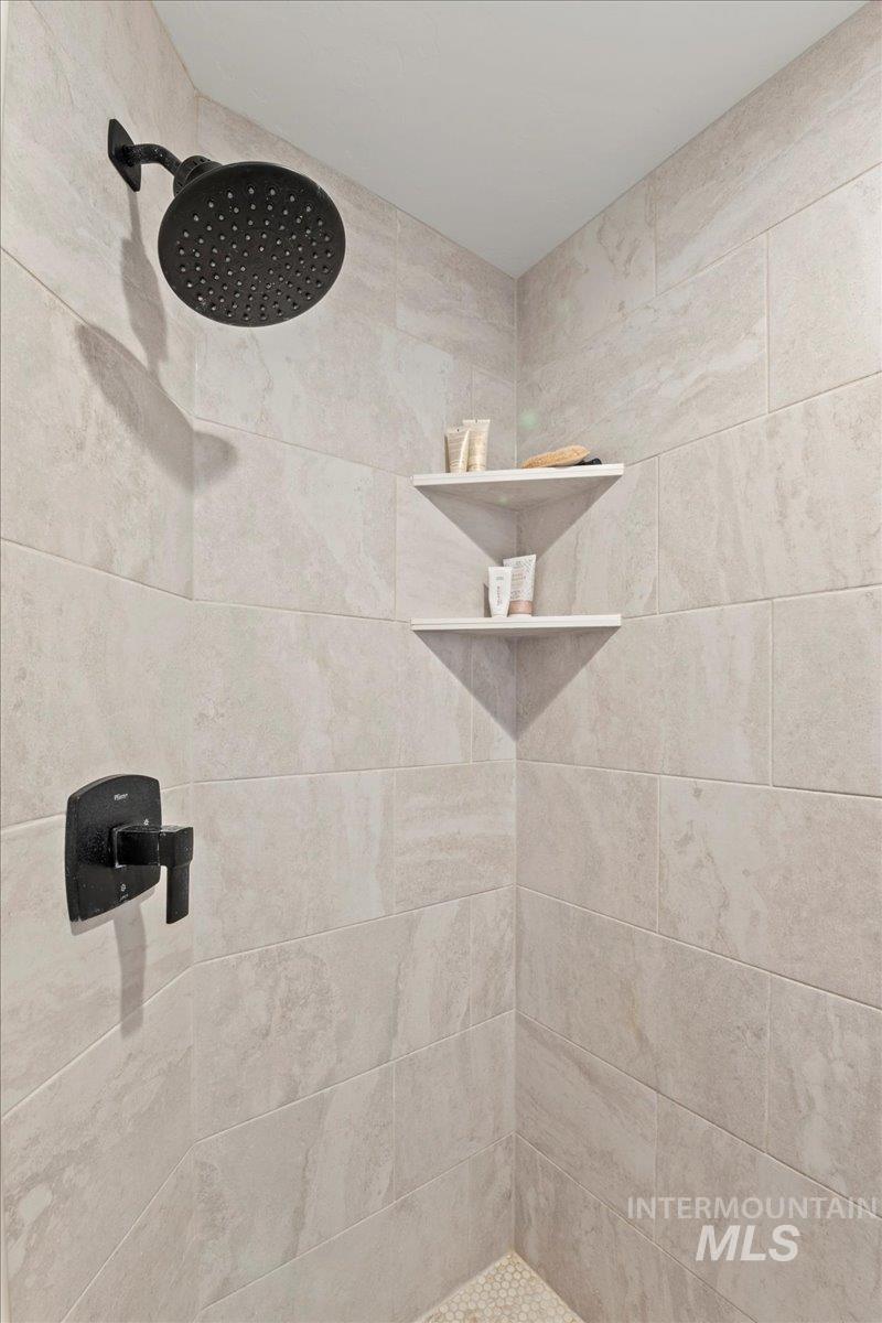Full bath featuring tiled shower