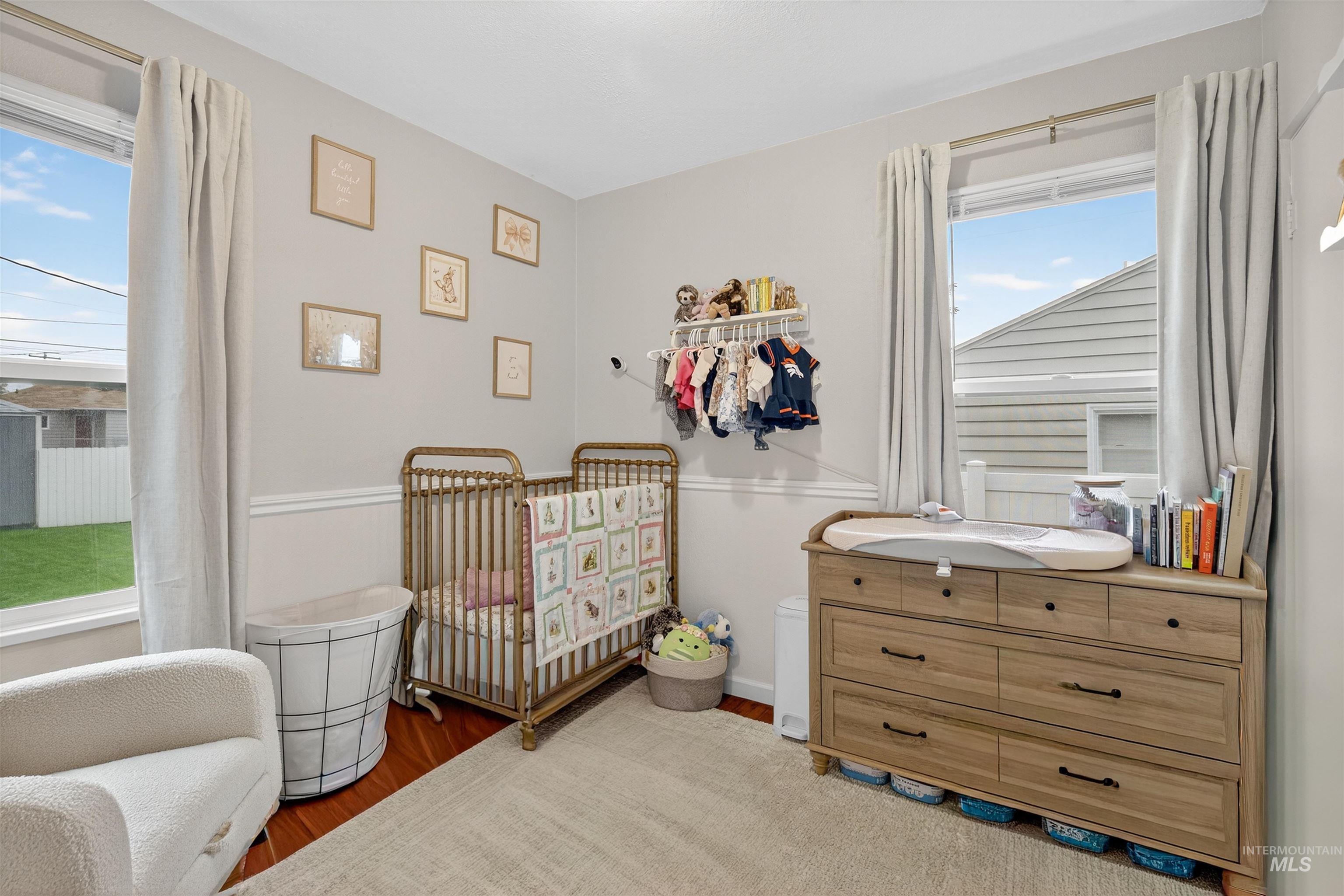 Bedroom featuring wood finished floors and a crib