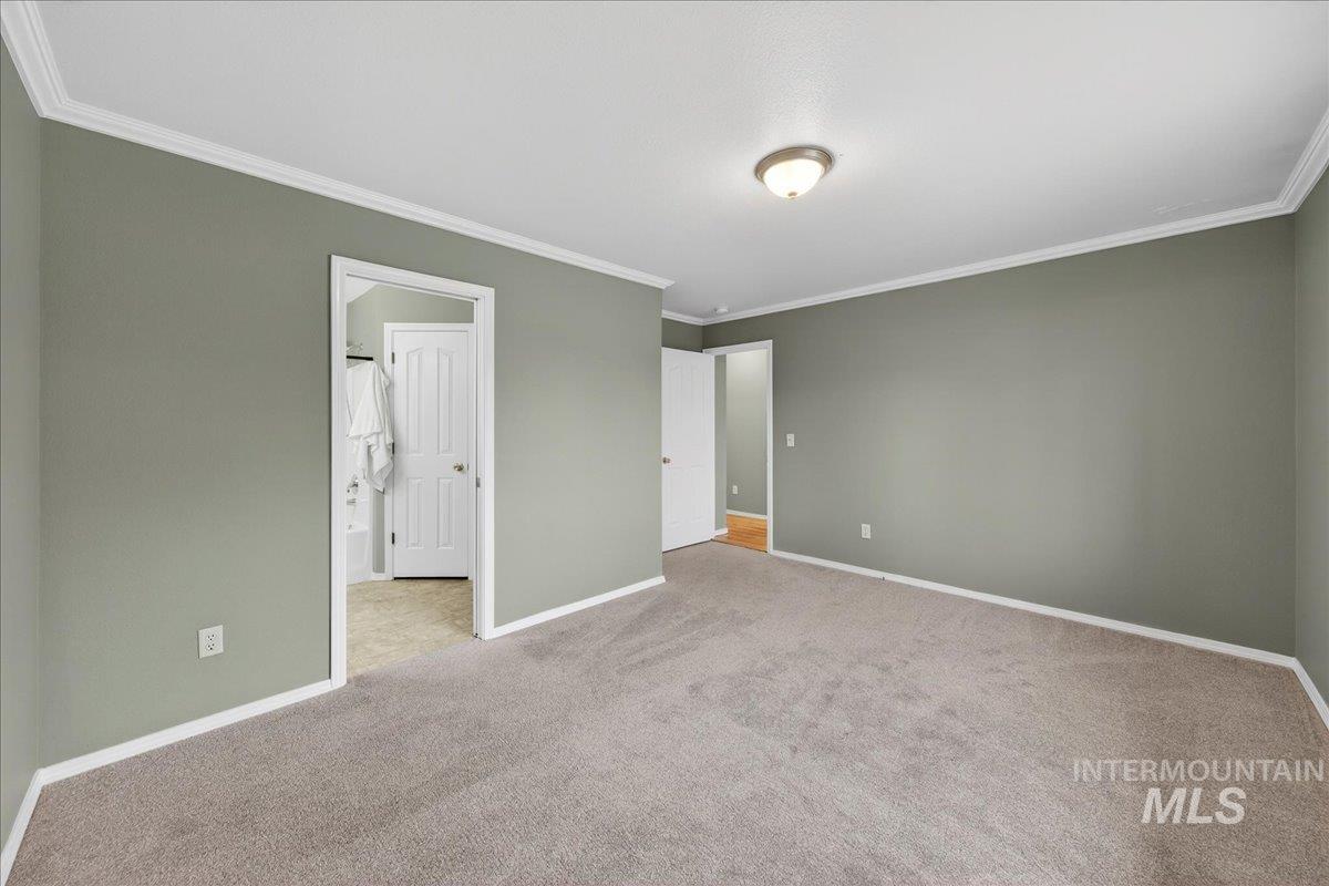 Unfurnished bedroom featuring light carpet and ornamental molding