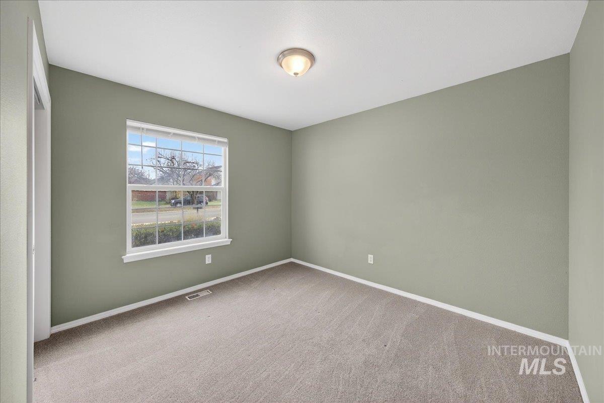 Spare room featuring carpet and baseboards