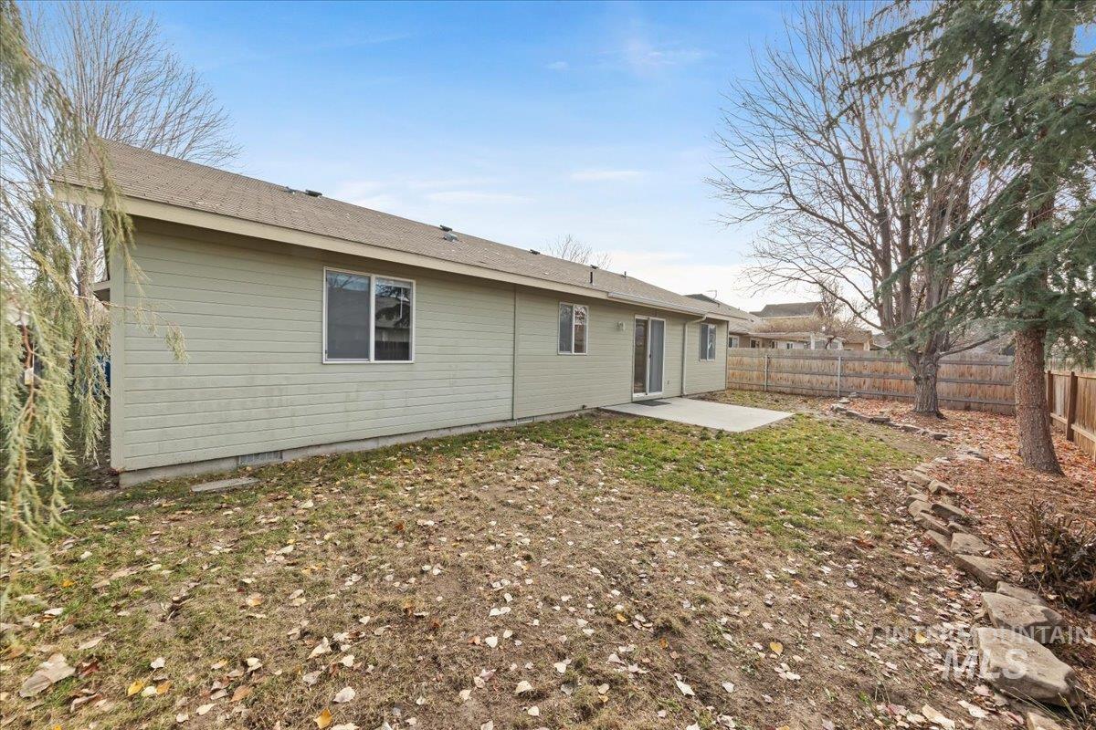 Back of house featuring a patio area, a fenced backyard, and a shingled roof