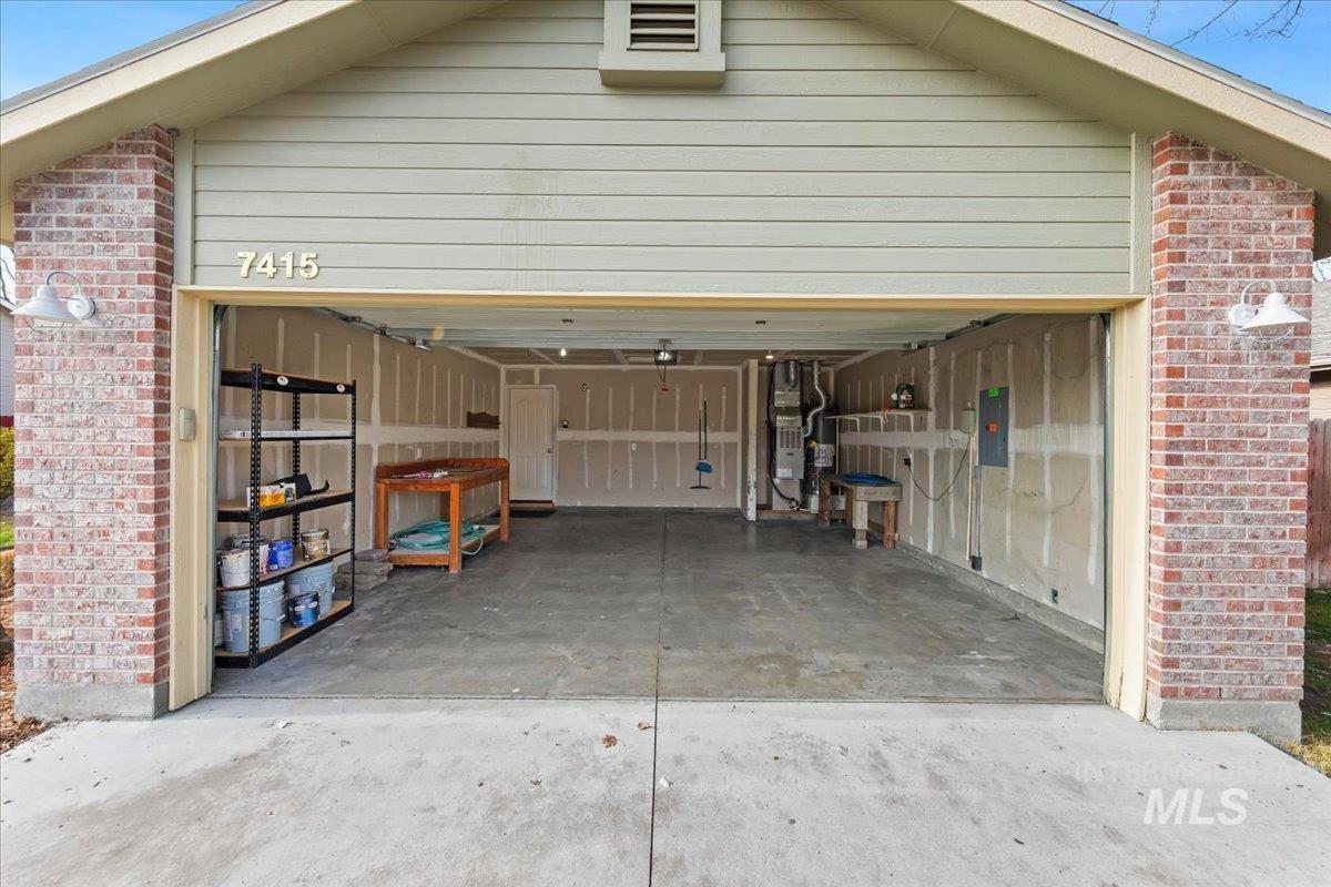 Garage with concrete driveway and electric panel
