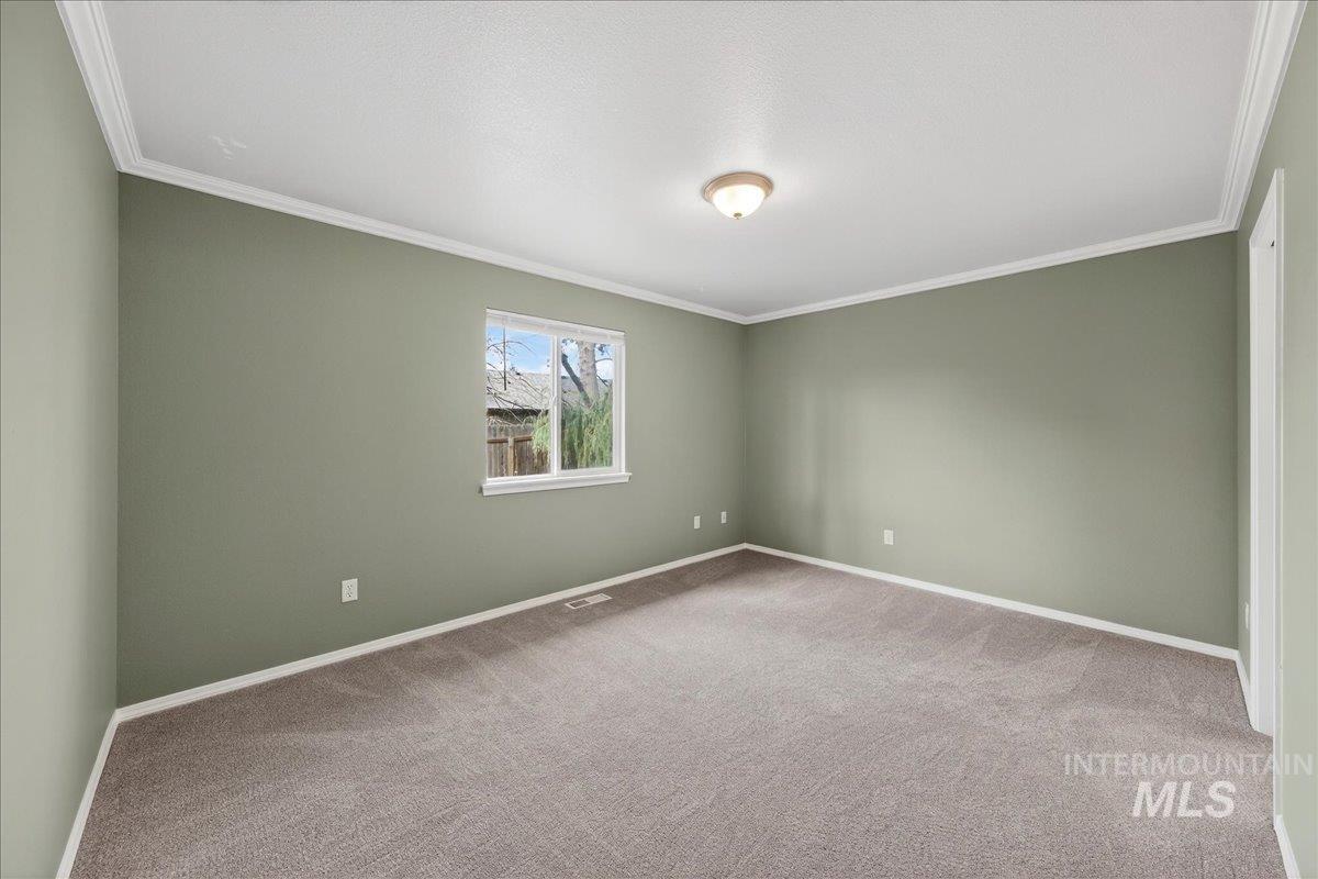 Carpeted empty room with ornamental molding