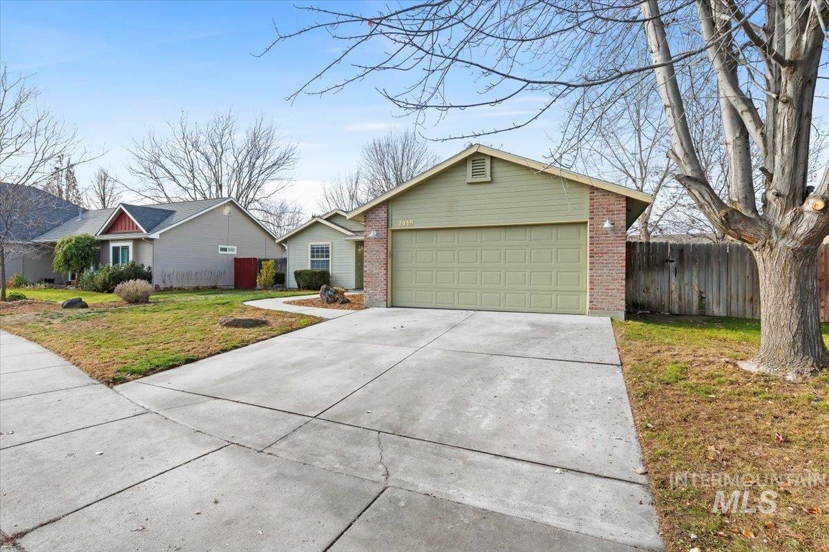 Ranch-style home with concrete driveway, brick siding, and a garage