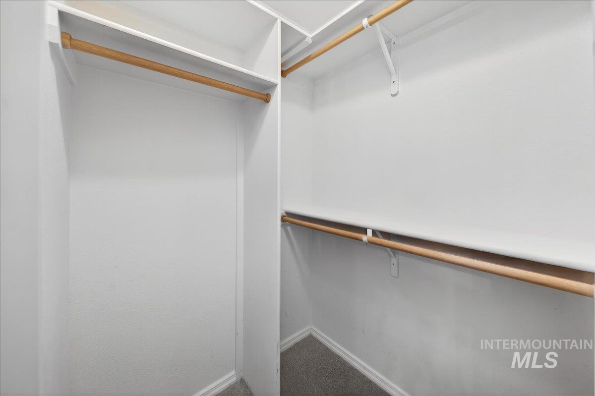 Walk in closet featuring dark carpet