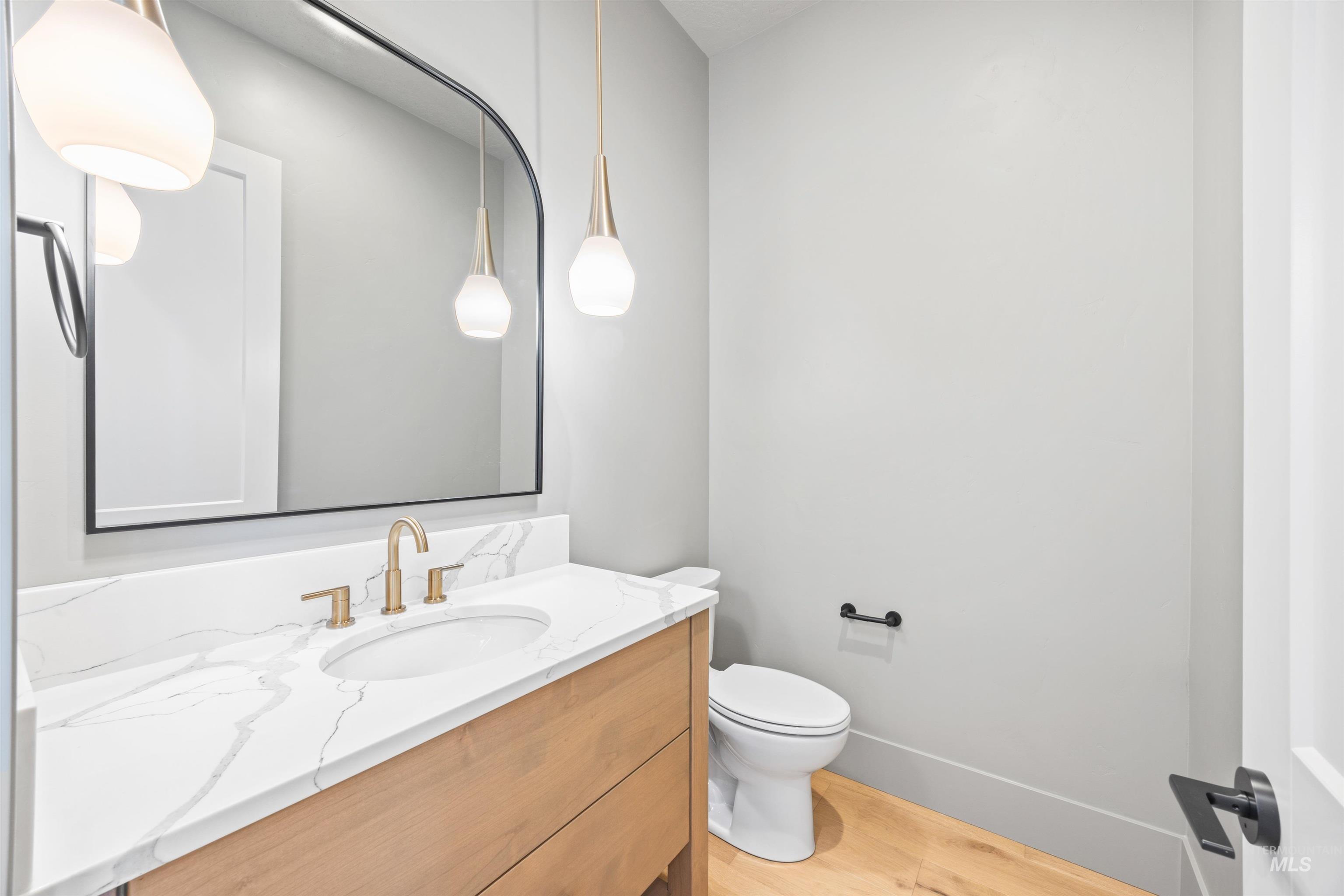 Half bath featuring vanity and light wood-style floors