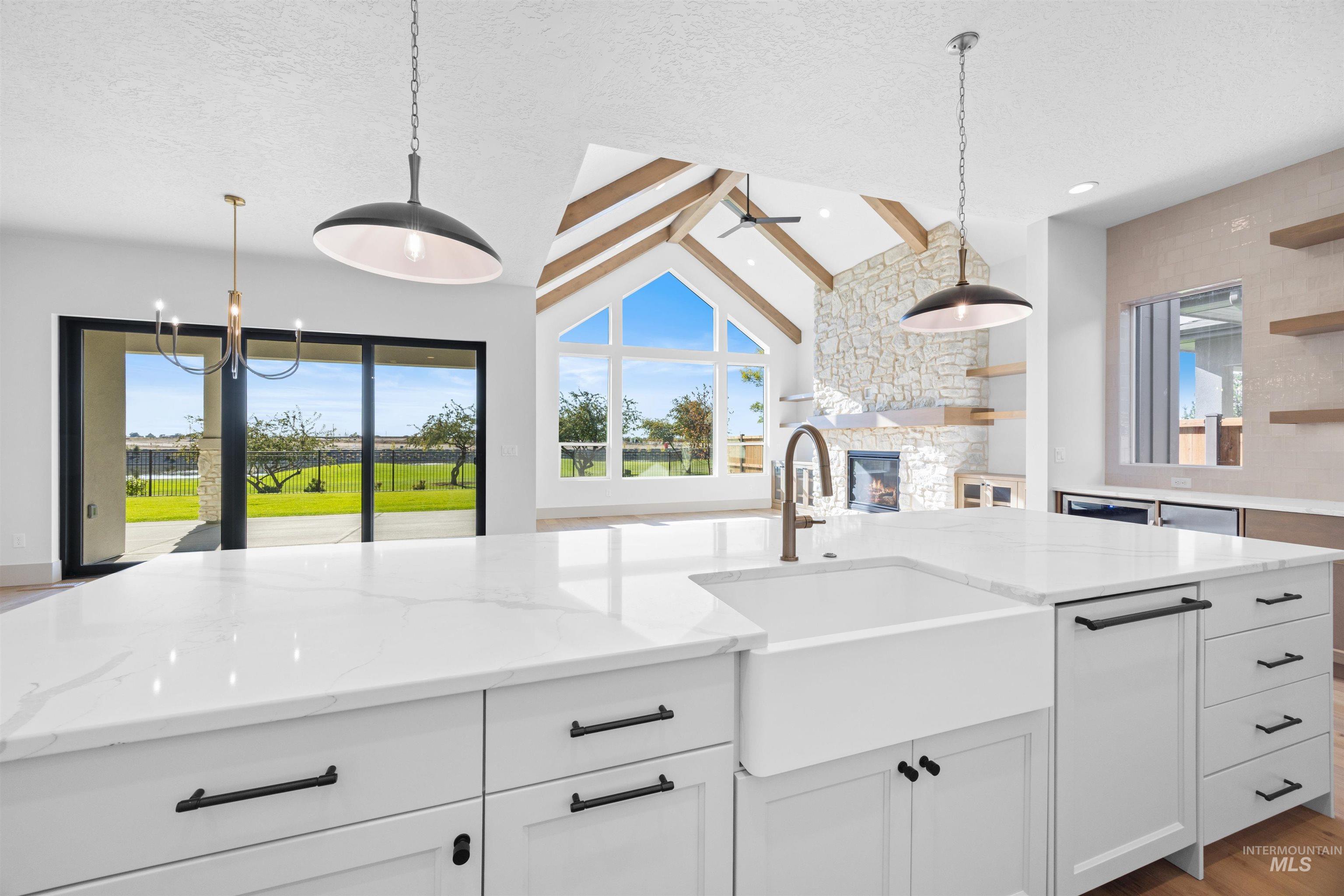Kitchen featuring white cabinets, pendant lighting, light stone counters, light wood-type flooring, and open shelves