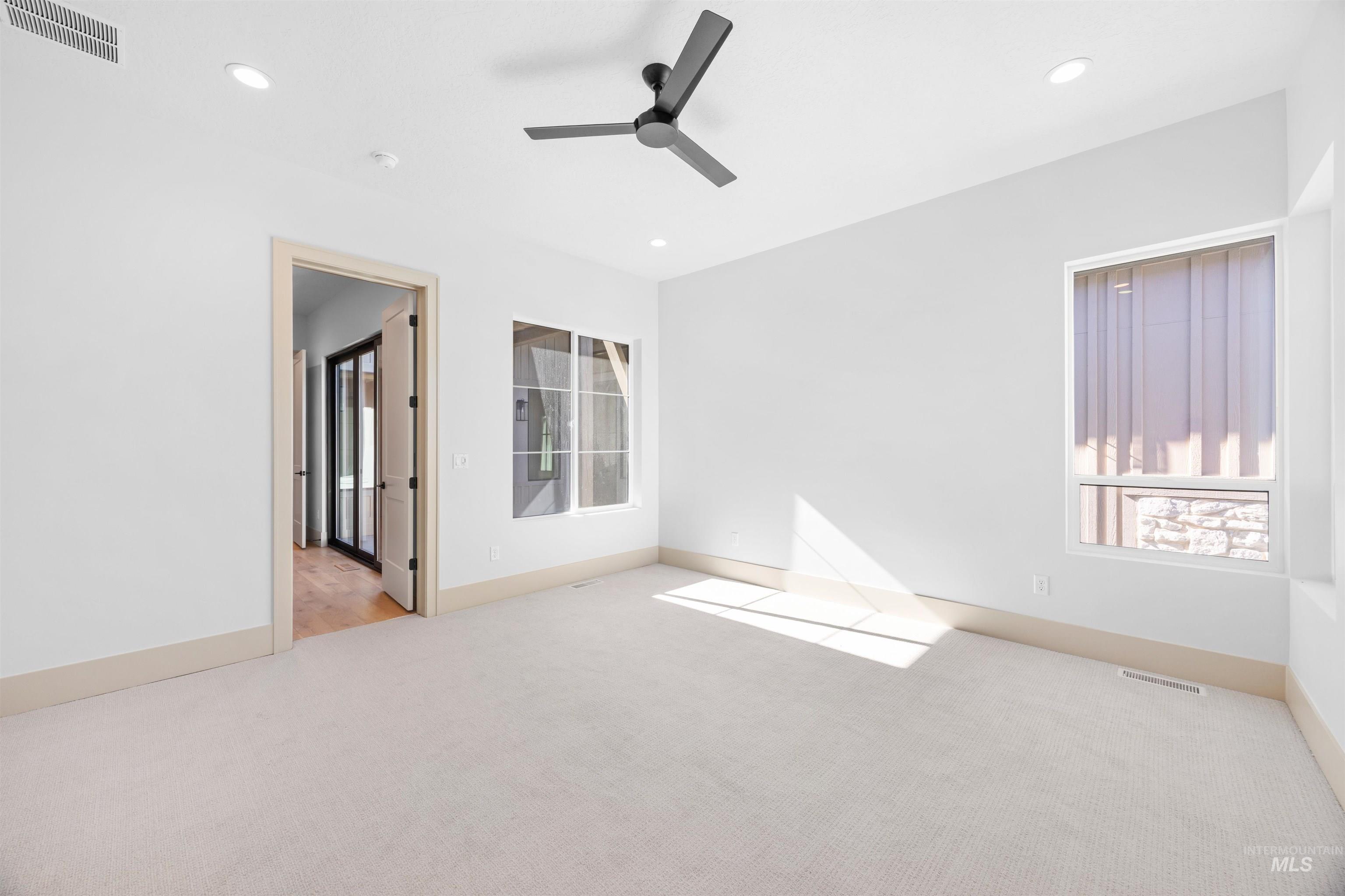 Spare room featuring light carpet, recessed lighting, and a ceiling fan