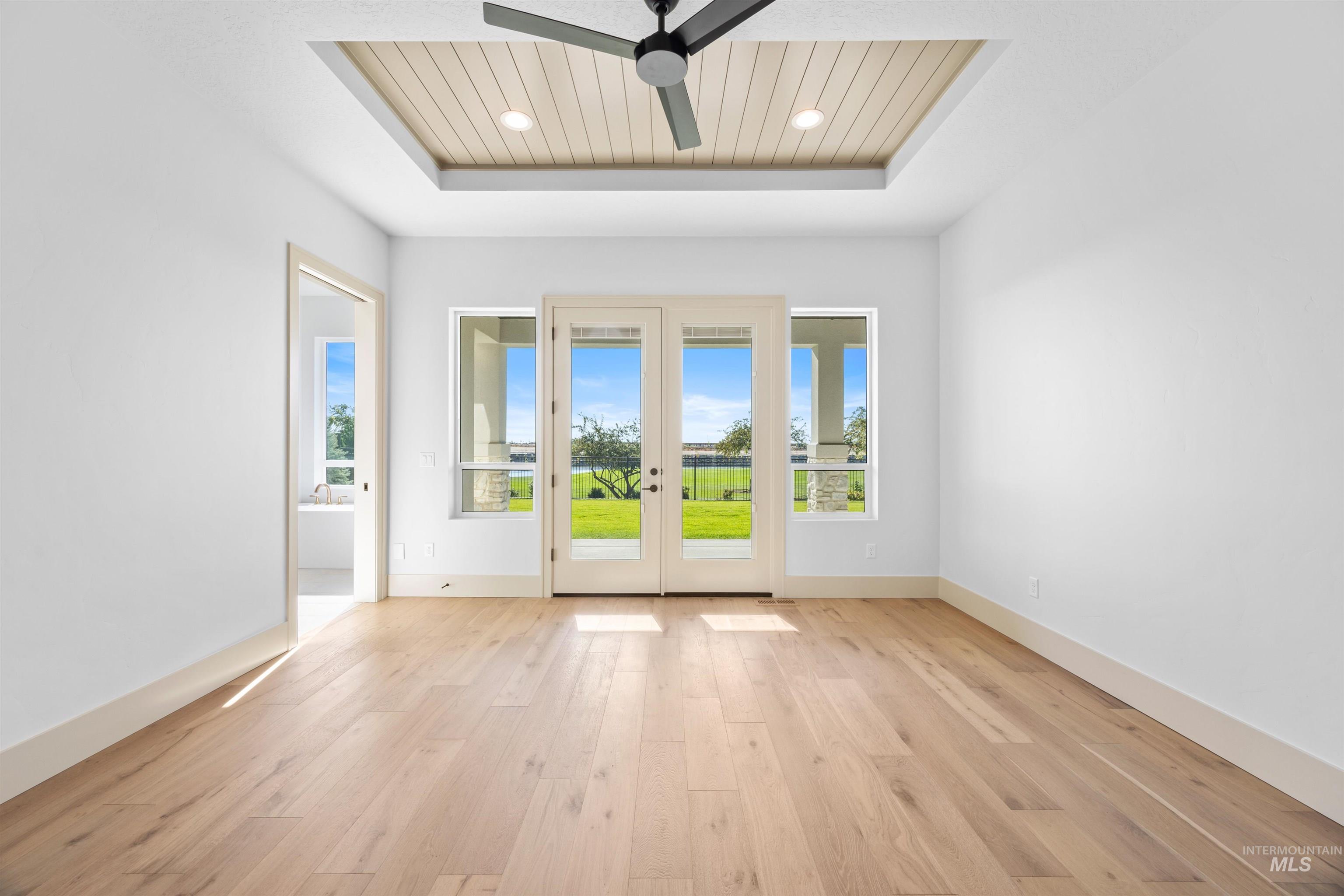 Empty room featuring light wood-type flooring, wood ceiling, french doors, recessed lighting, and a ceiling fan