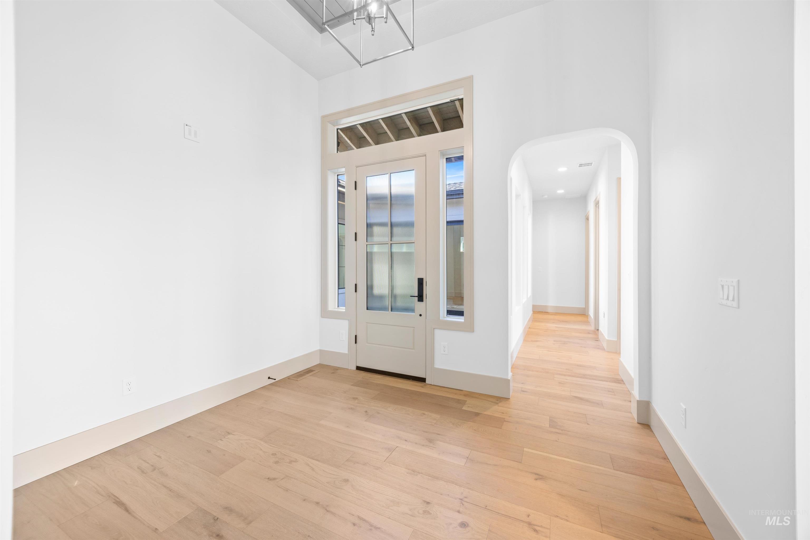 Entryway featuring light wood-style flooring and arched walkways