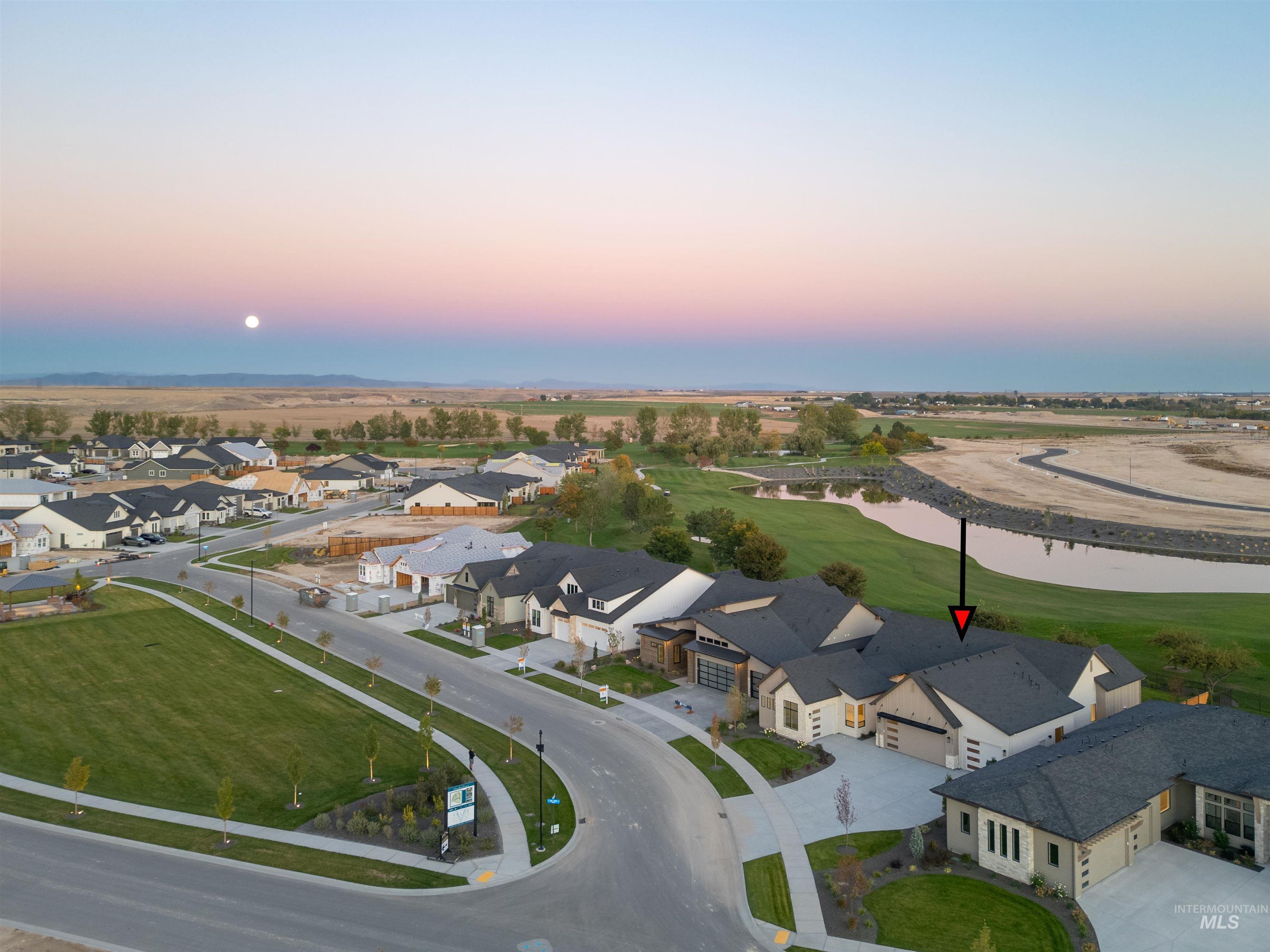 Aerial perspective of suburban area featuring a nearby body of water and a local golf course