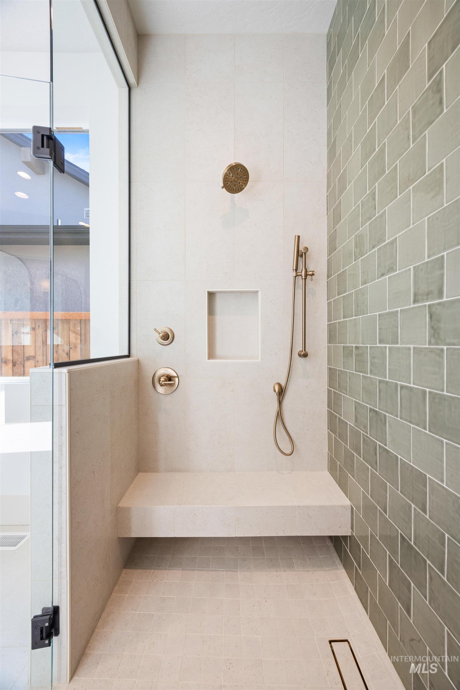 Bathroom featuring tiled shower and tile walls