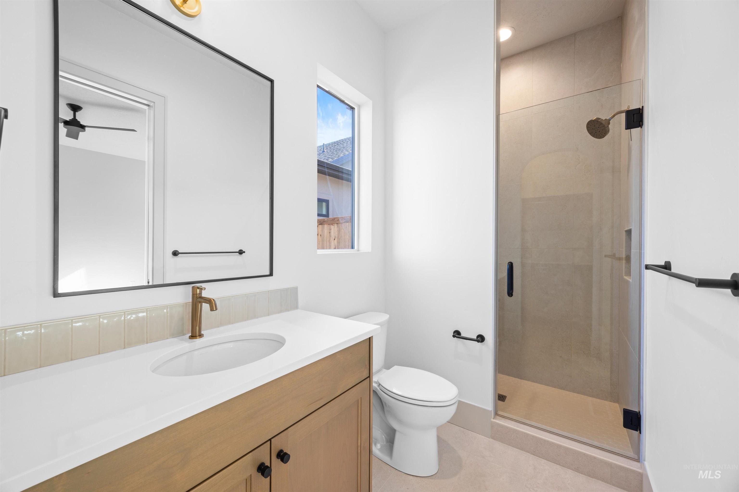 Bathroom featuring a stall shower, vanity, and light tile patterned floors