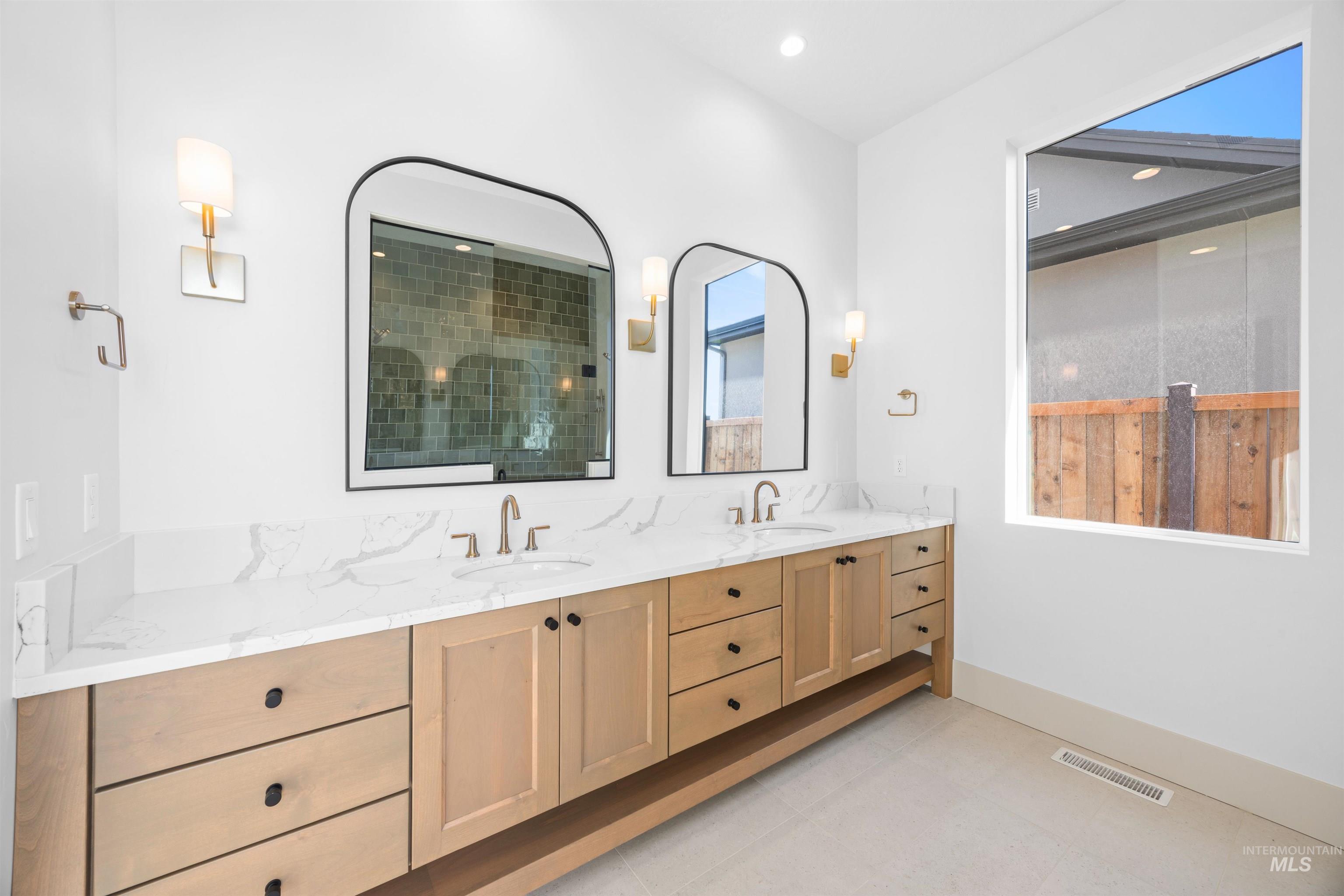 Full bathroom featuring double vanity, a stall shower, light tile patterned floors, and recessed lighting