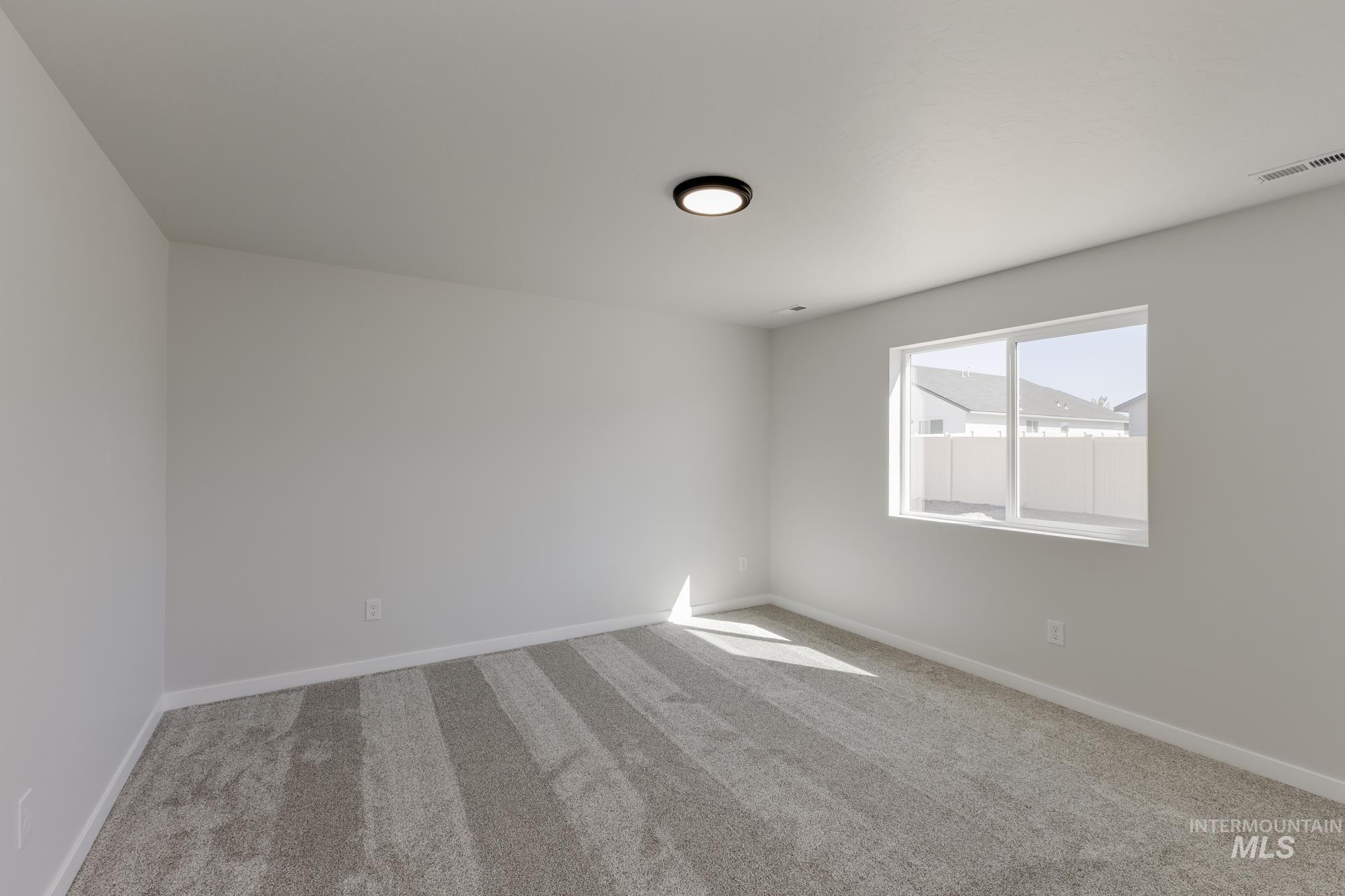 Empty room with carpet flooring and baseboards