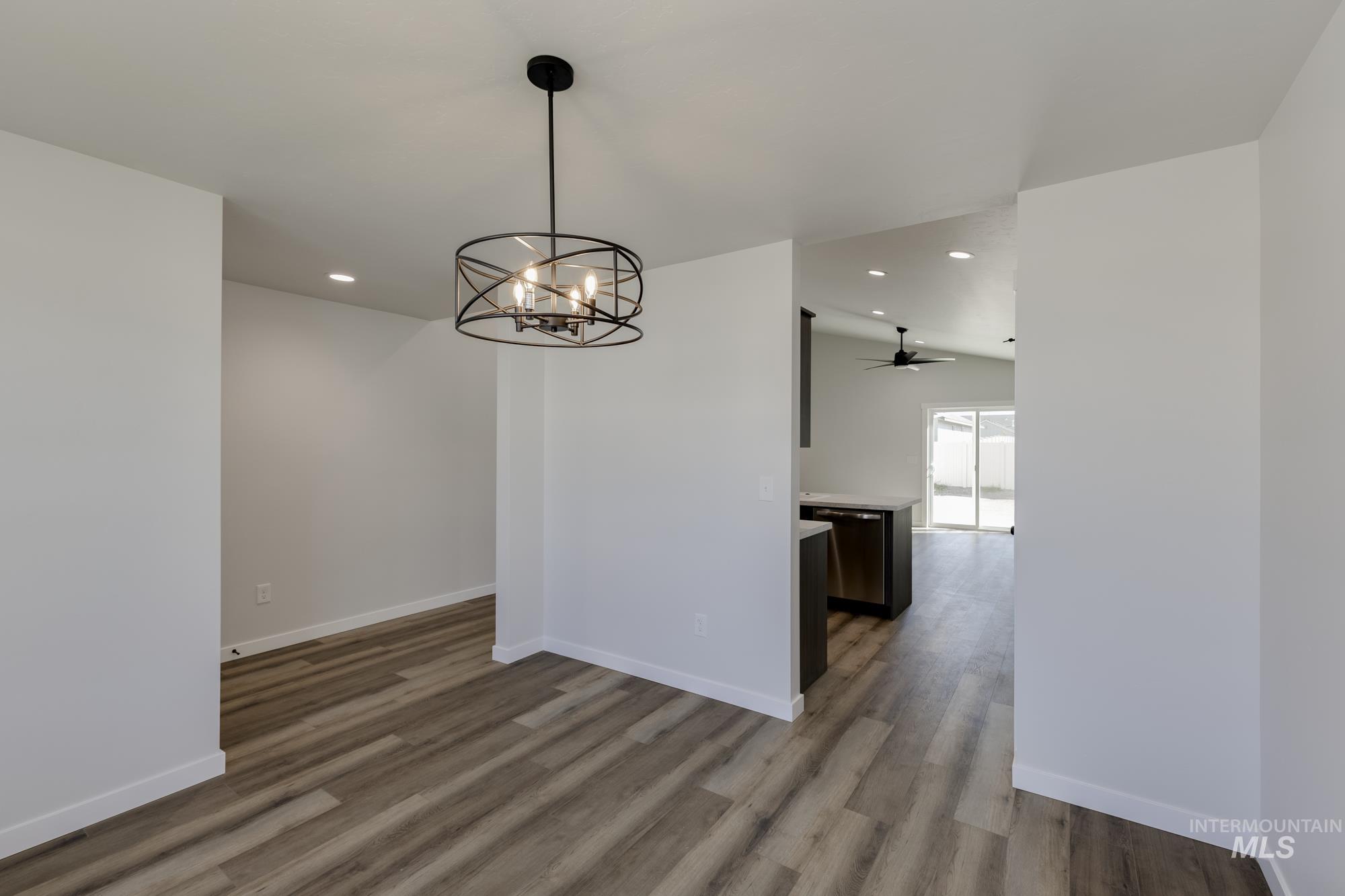 Unfurnished dining area featuring ceiling fan, recessed lighting, light wood-style floors, and a chandelier