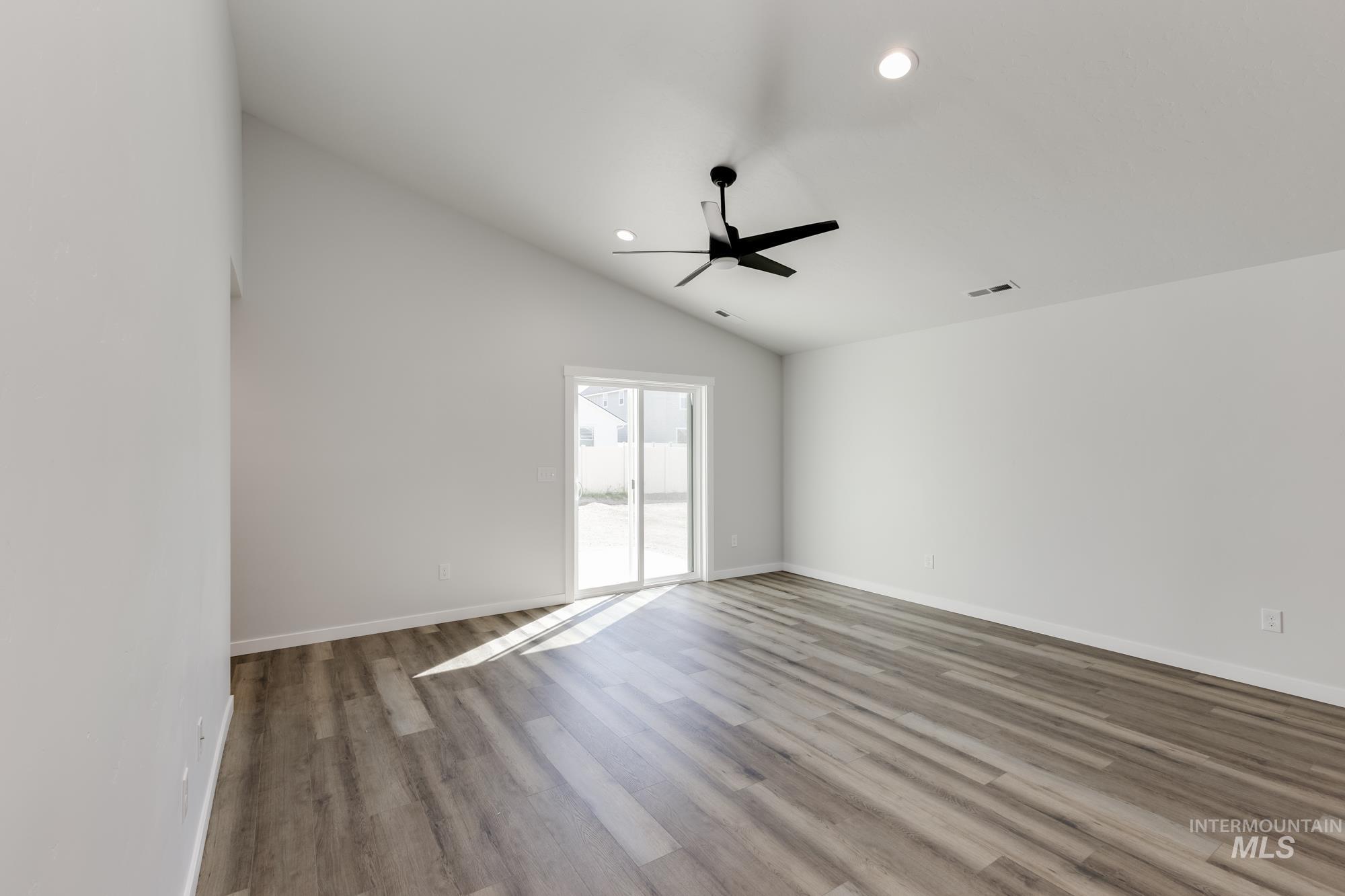 Empty room with vaulted ceiling, light wood-type flooring, recessed lighting, and a ceiling fan