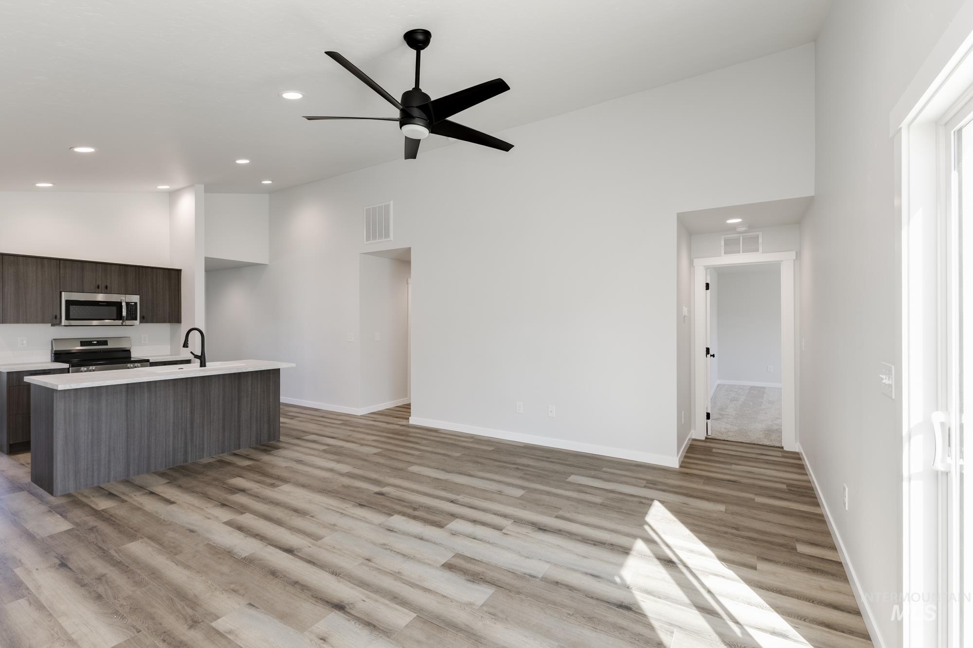 Kitchen featuring an island with sink, modern cabinets, recessed lighting, a ceiling fan, and appliances with stainless steel finishes