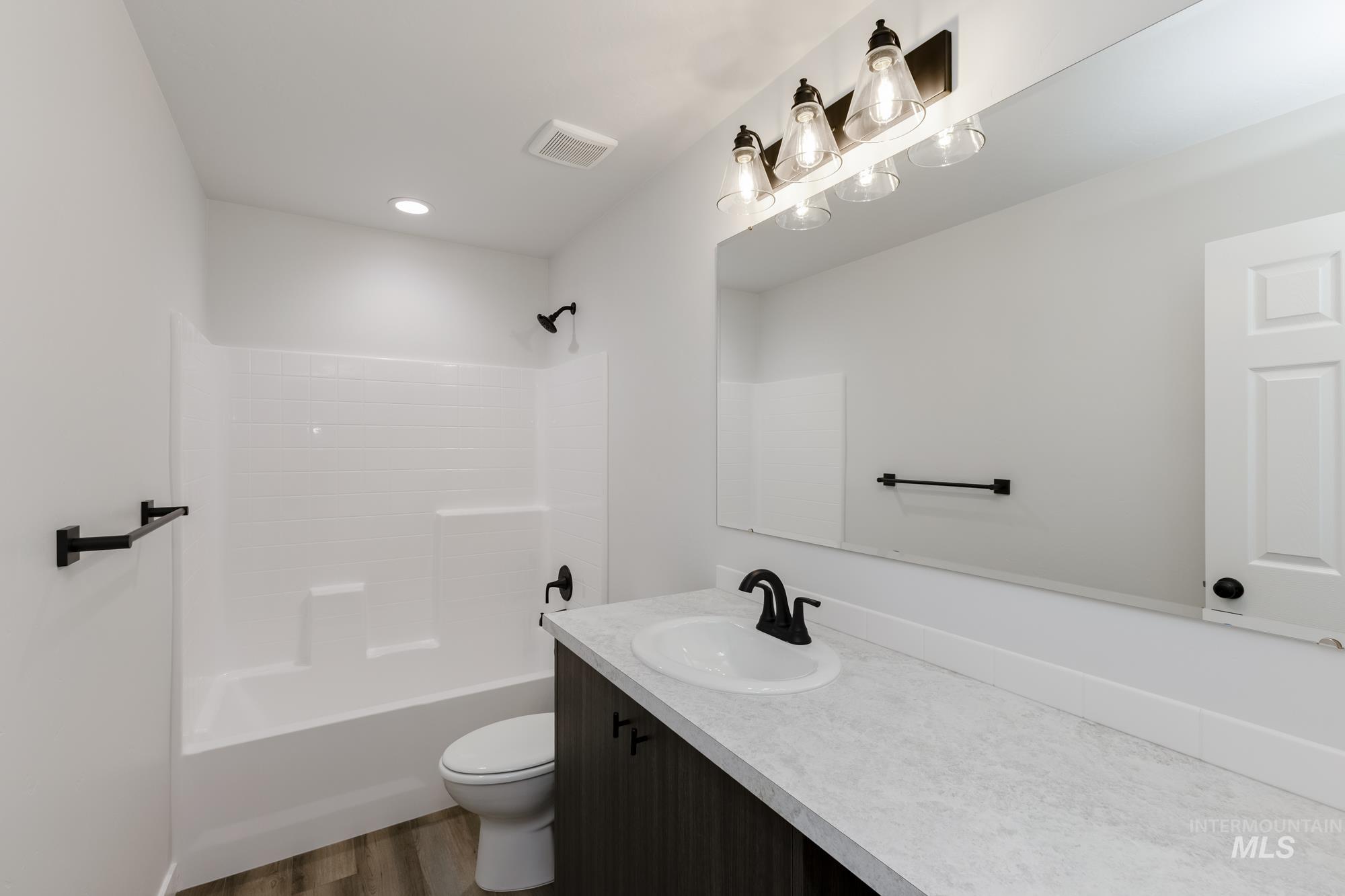 Full bathroom featuring vanity, washtub / shower combination, dark wood finished floors, and recessed lighting