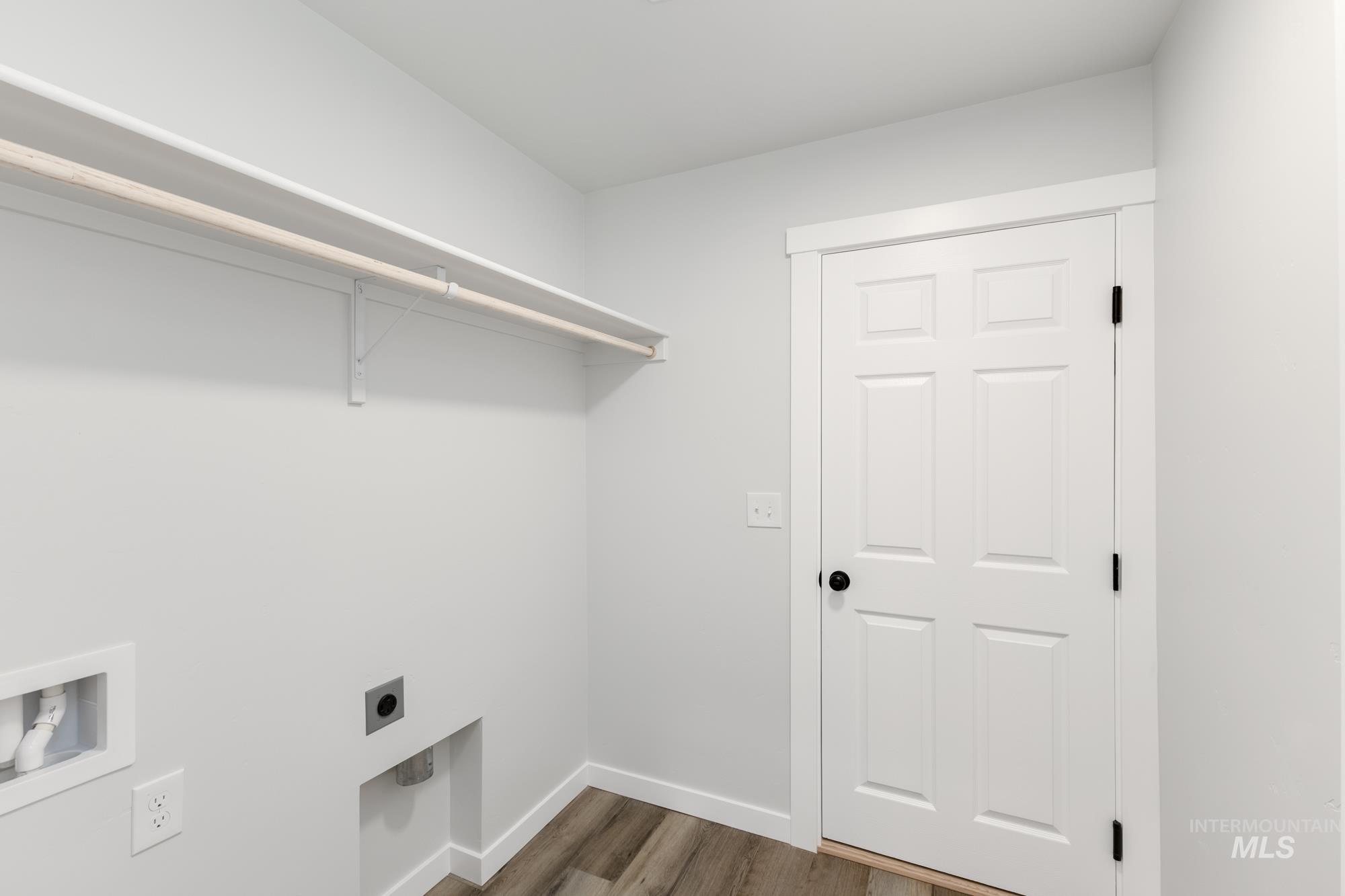 Laundry area with dark wood-style flooring, hookup for an electric dryer, and washer hookup
