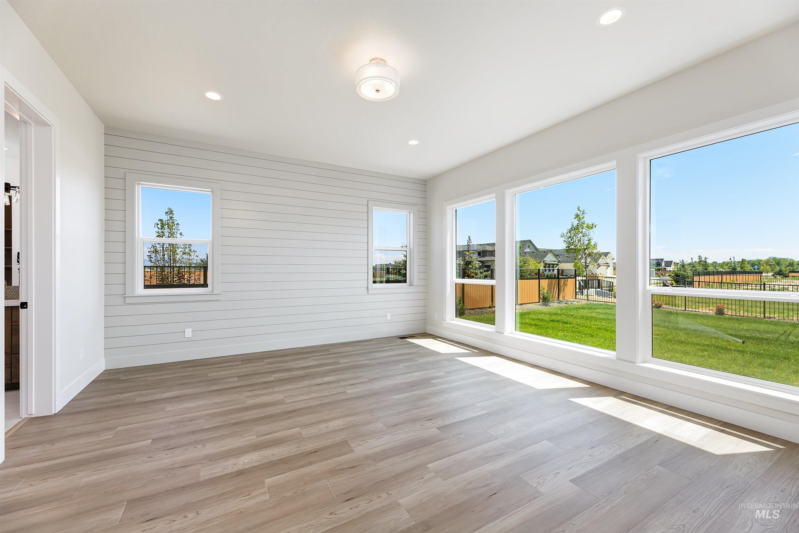 Unfurnished sunroom with wood finished floors, recessed lighting, and wood walls