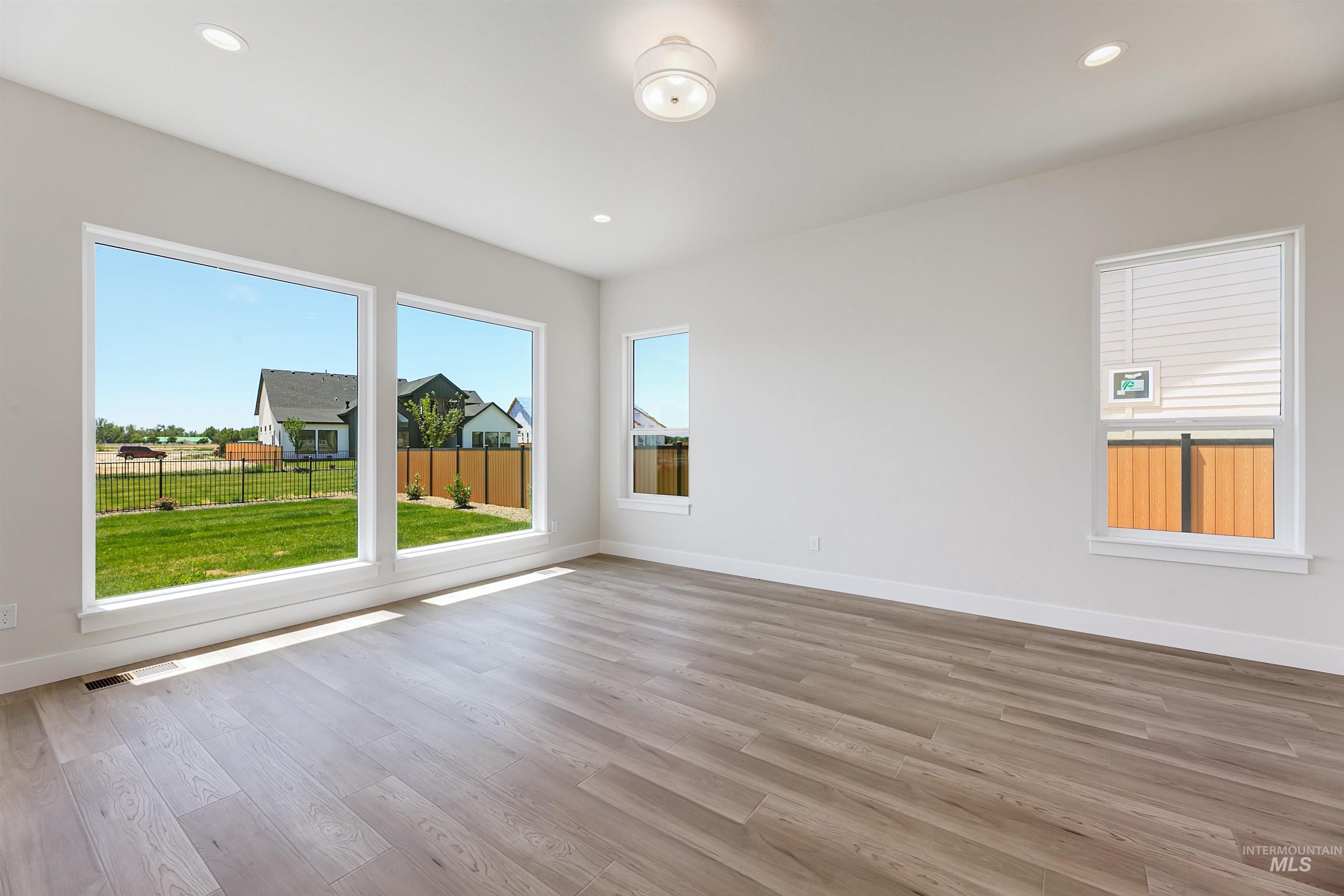 Unfurnished room with light wood finished floors, plenty of natural light, and recessed lighting