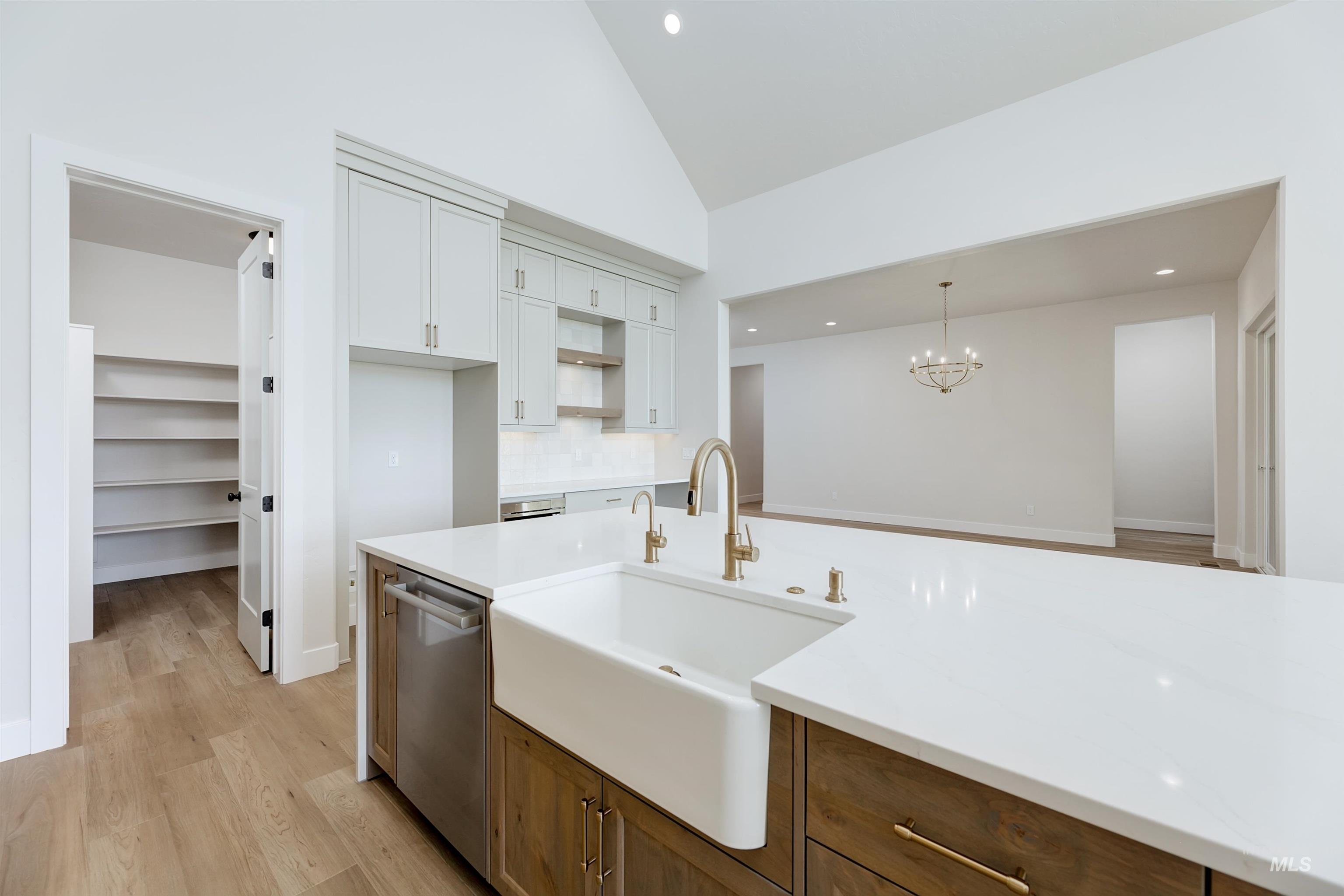 Kitchen featuring backsplash, light wood-style flooring, stainless steel dishwasher, brown cabinetry, and recessed lighting