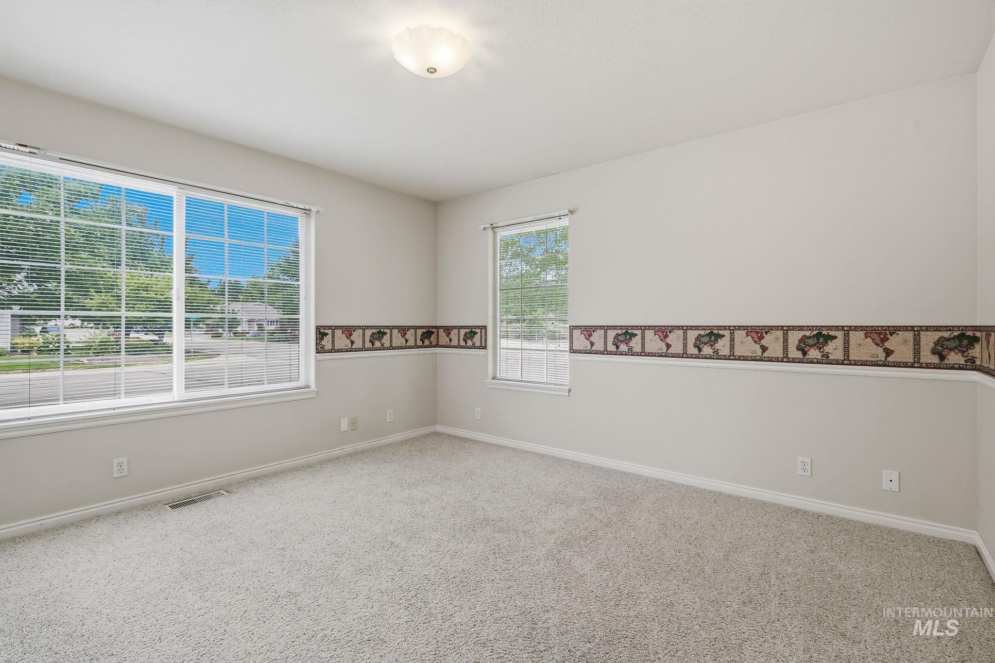 Carpeted room with a large paneled window featuring blinds