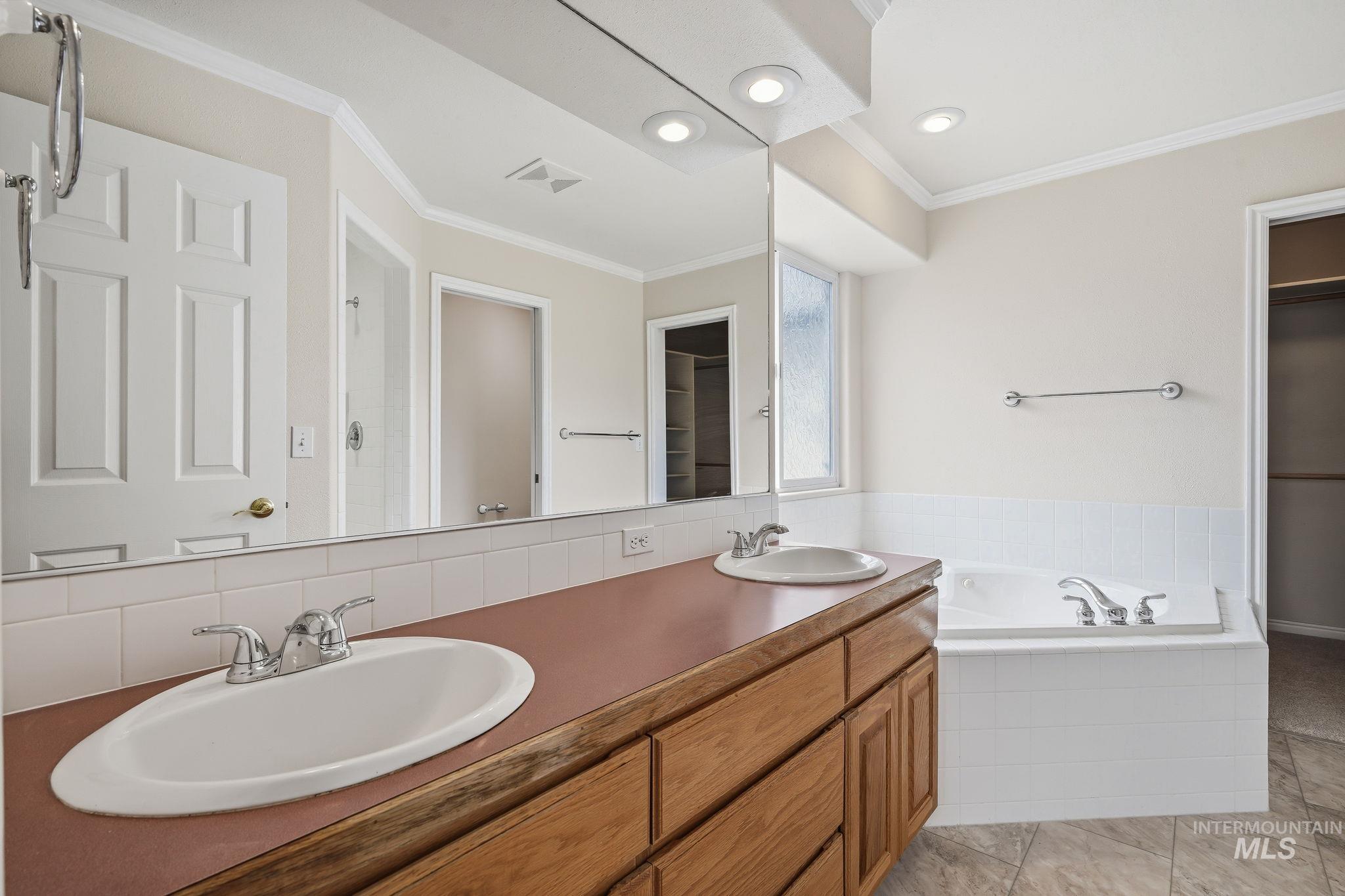 Bathroom featuring a dual vanity with wood-finish cabinetry and integrated sinks