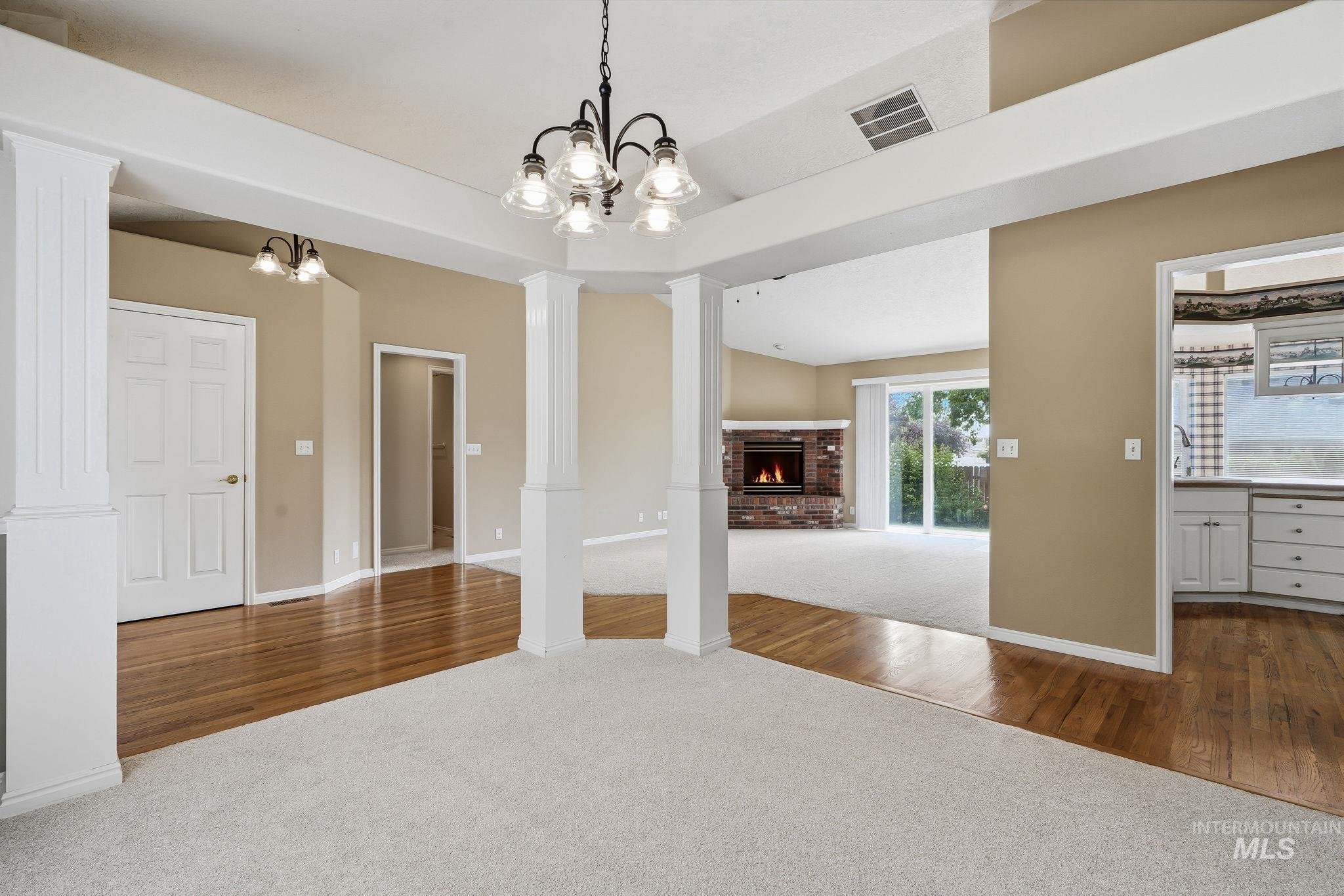 Spacious interior with mixed flooring, featuring light carpeting and wood-finish flooring