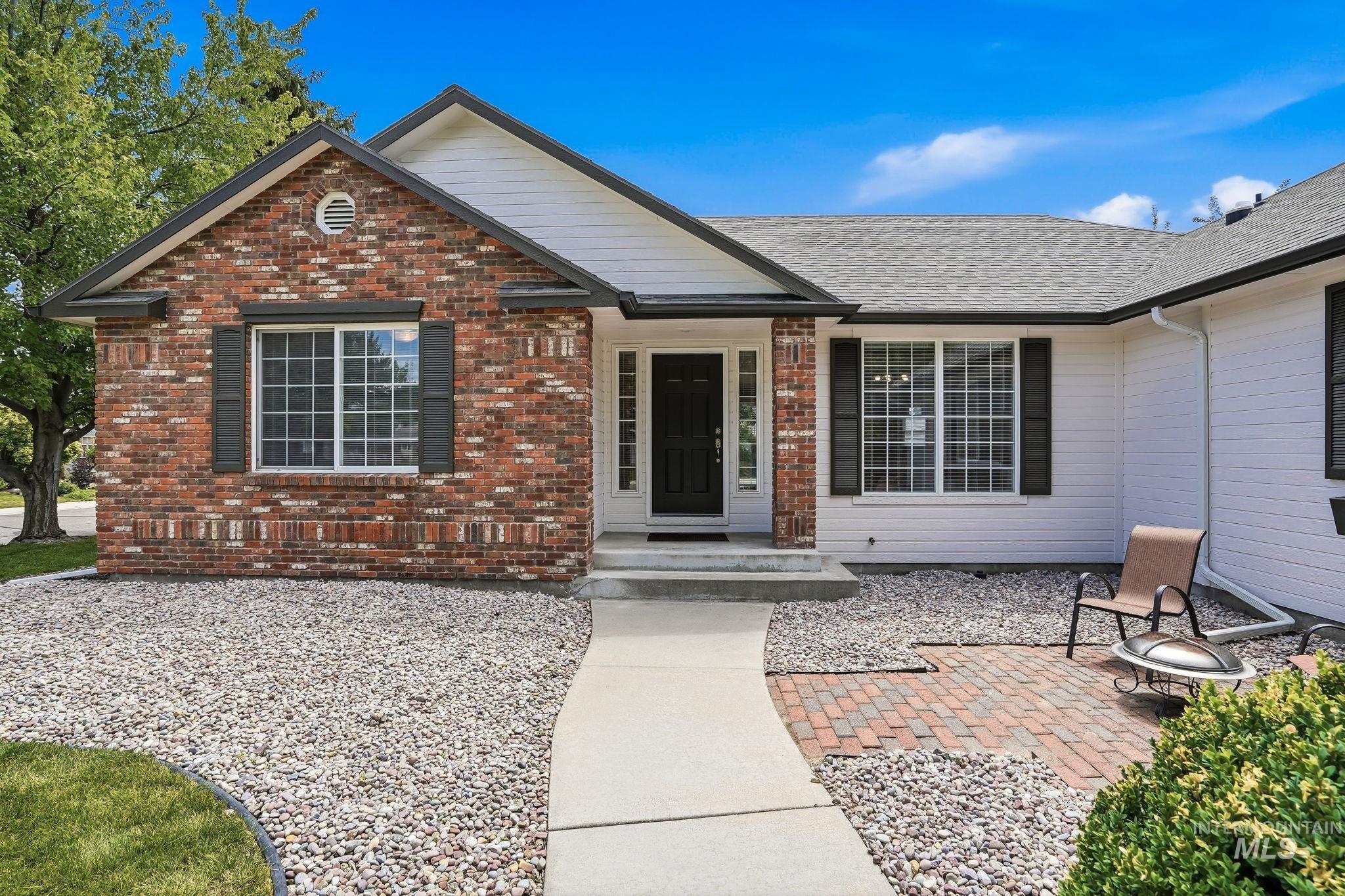 Brick and siding exterior with a dark-paneled entry door