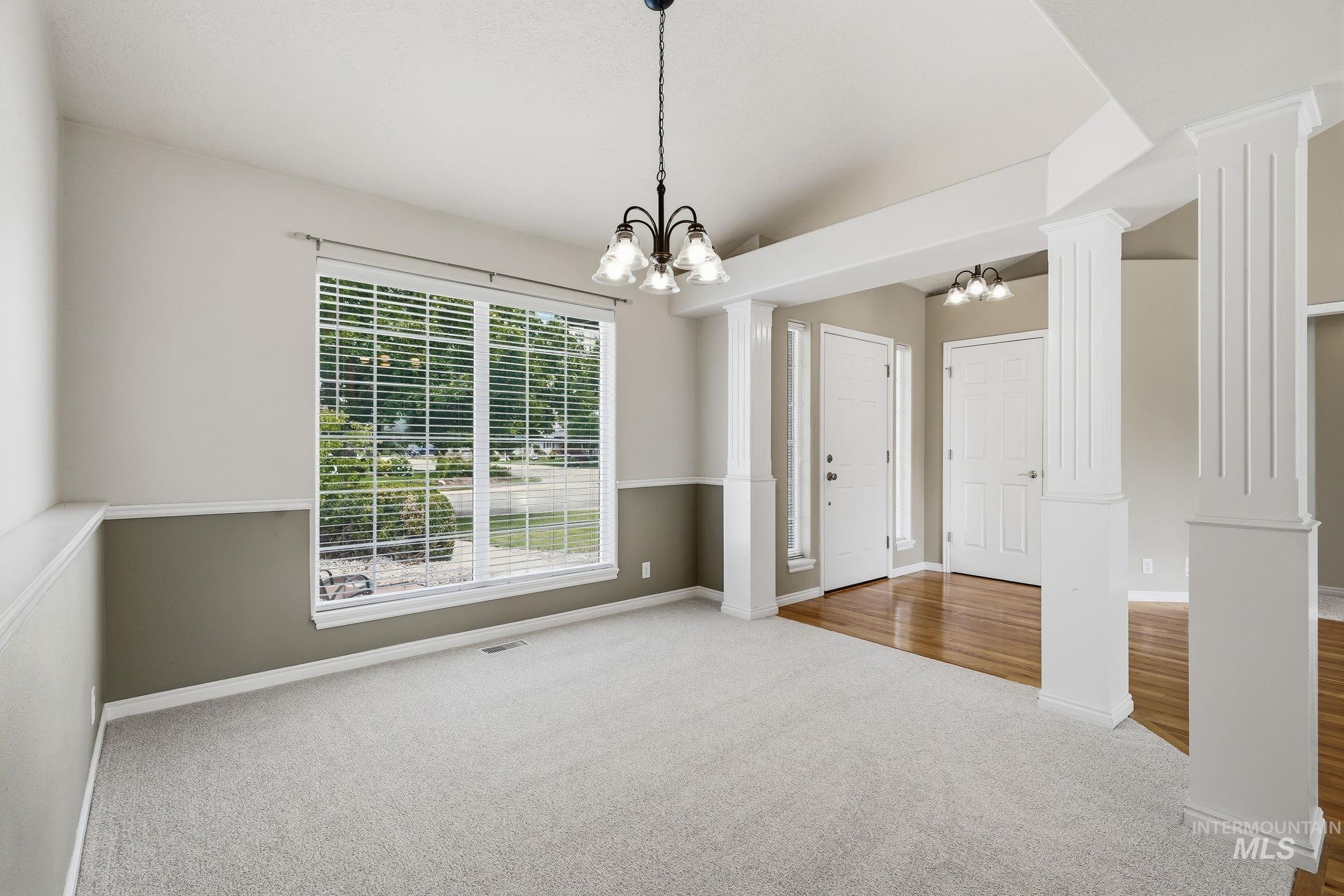 Spacious interior featuring a large window with horizontal blinds, providing ample natural light