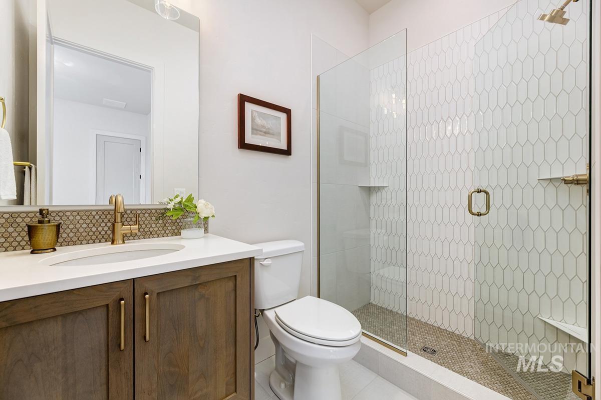 Bathroom featuring vanity, a stall shower, and tile patterned flooring