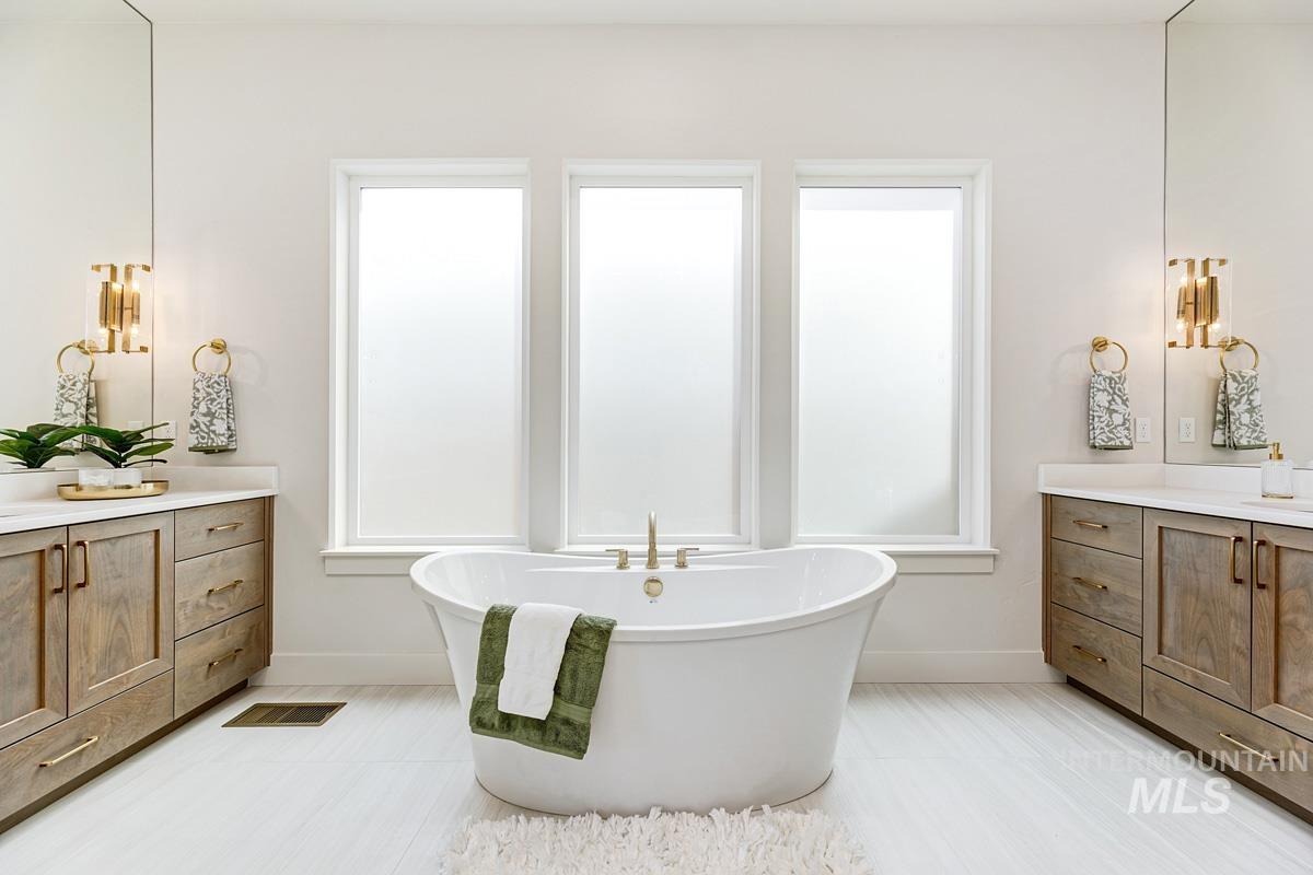 Bathroom featuring vanity, a soaking tub, and plenty of natural light
