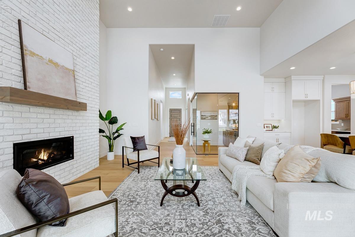 Living room with light wood-style flooring, a brick fireplace, and recessed lighting