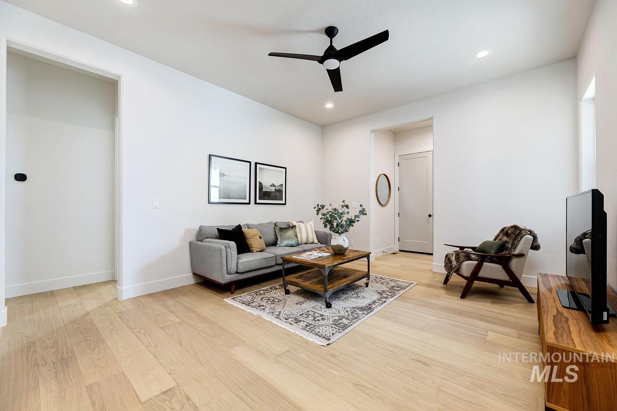 Living area with light wood-style floors, a ceiling fan, and recessed lighting