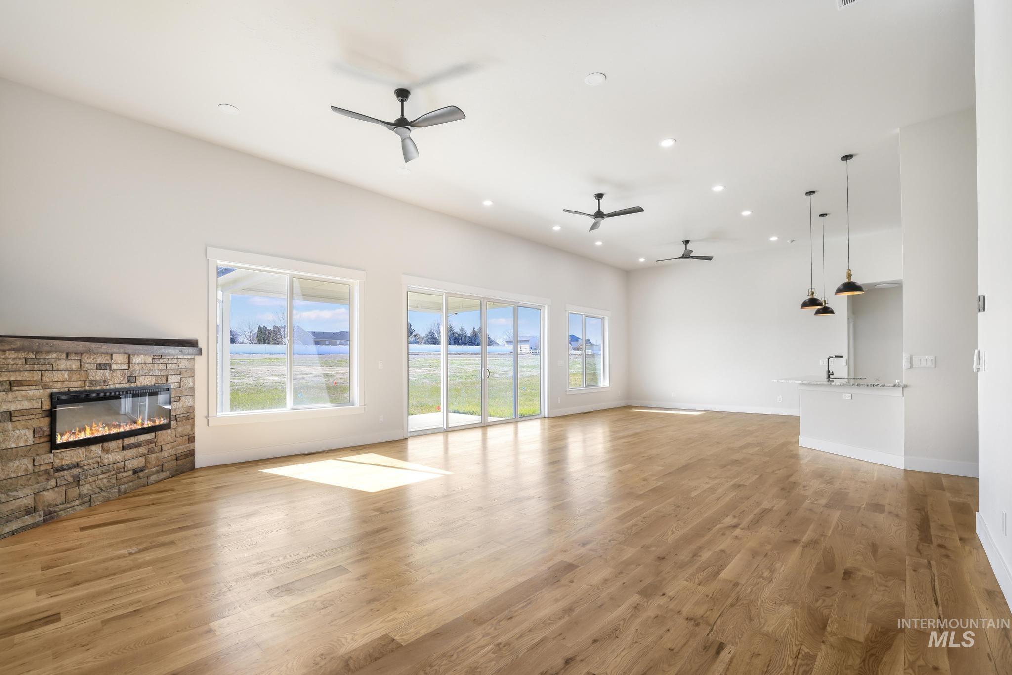 Unfurnished living room with a fireplace, light wood-style floors, recessed lighting, and ceiling fan