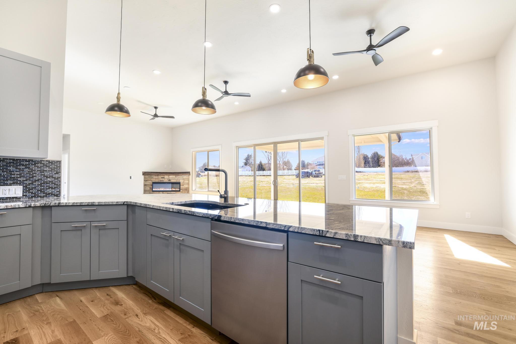 Kitchen featuring ceiling fan, gray cabinetry, and light wood-type flooring