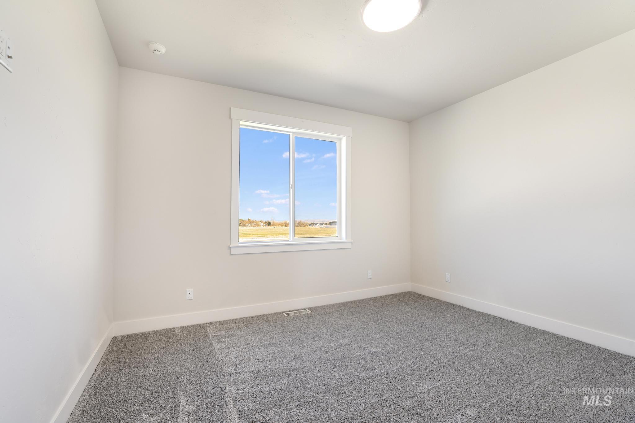Carpeted empty room featuring baseboards