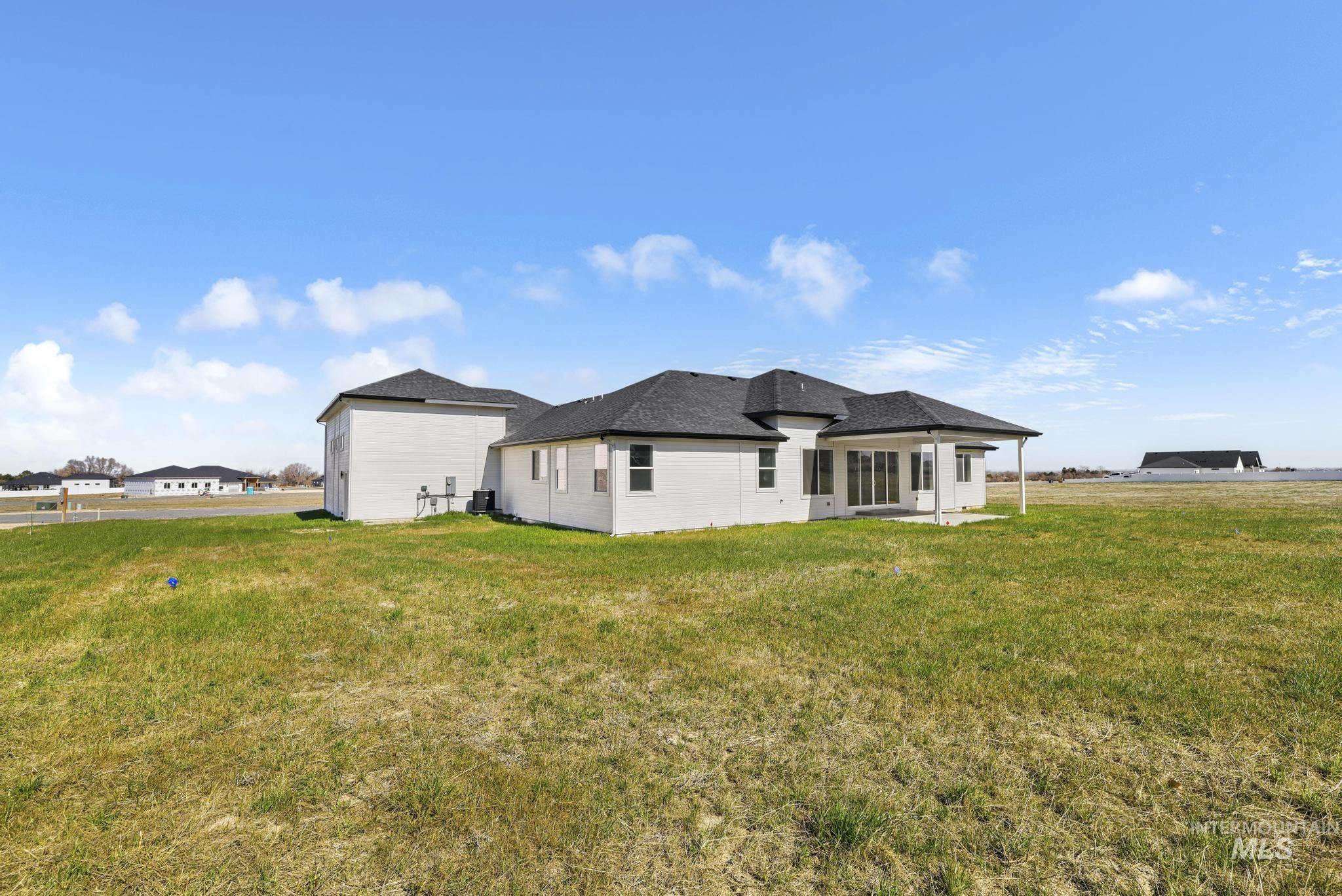 Rear view of house featuring a patio and a lawn
