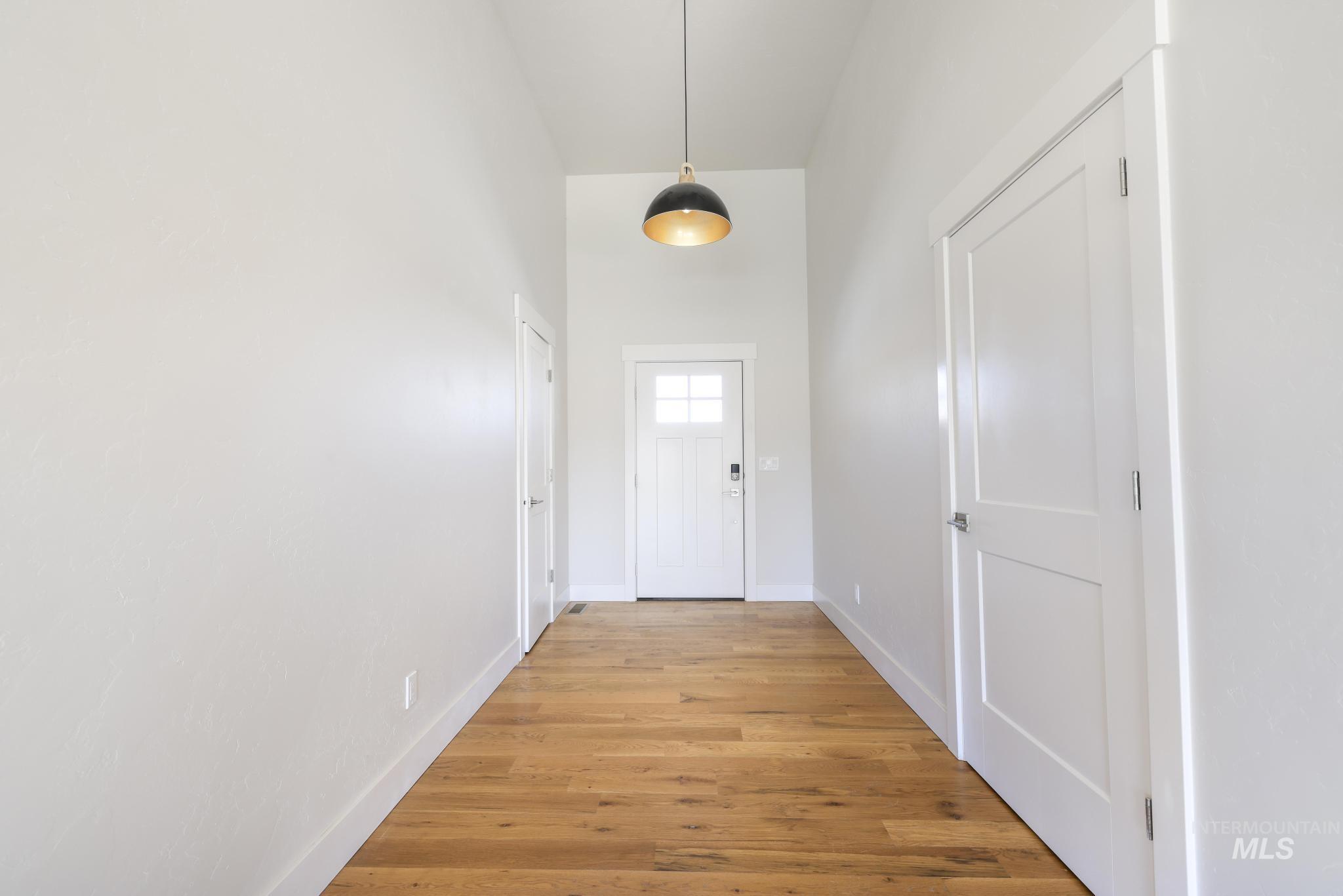 Doorway featuring wood finished floors and a high ceiling