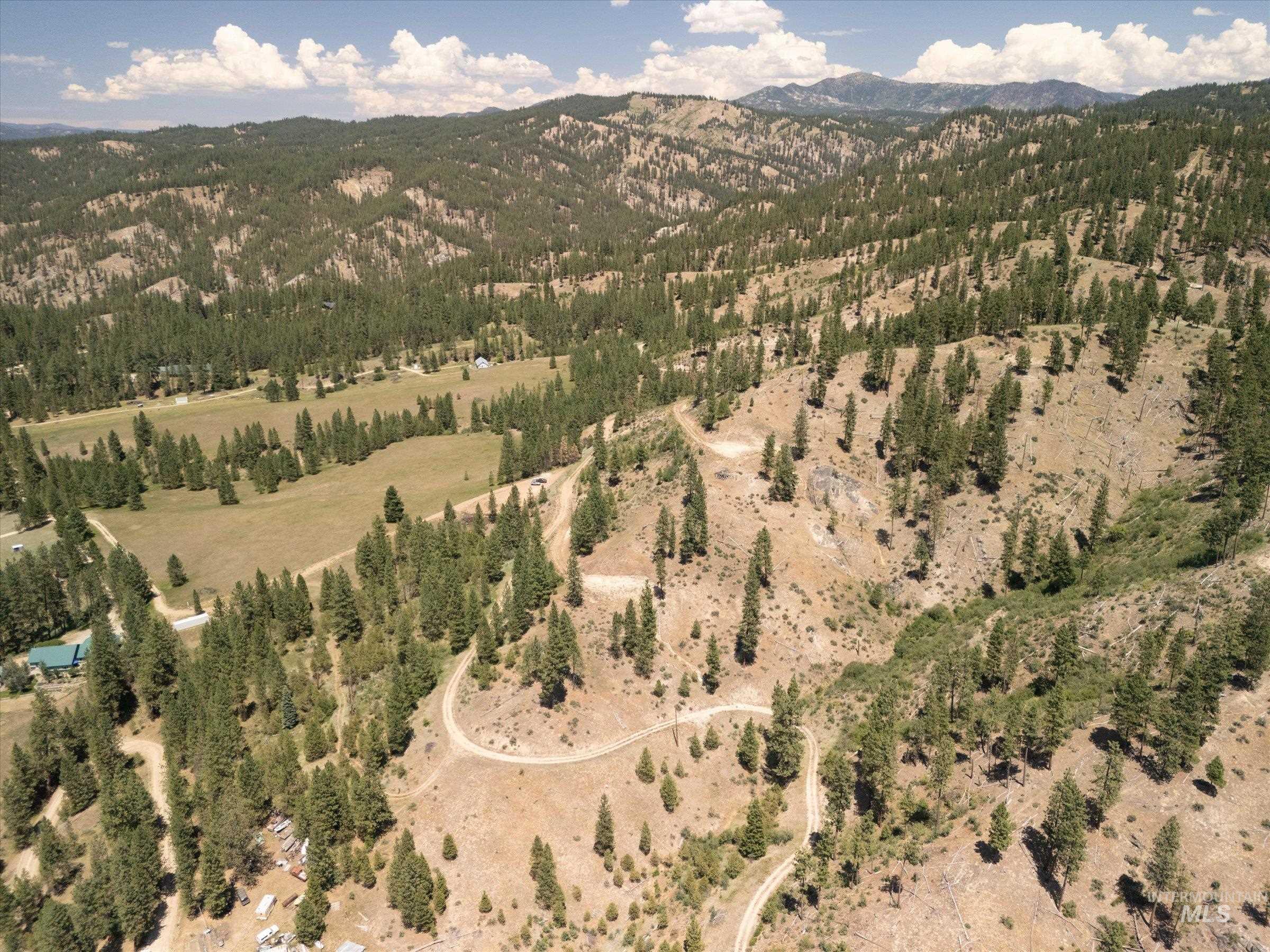 Aerial view of property and surrounding area featuring a mountainous background